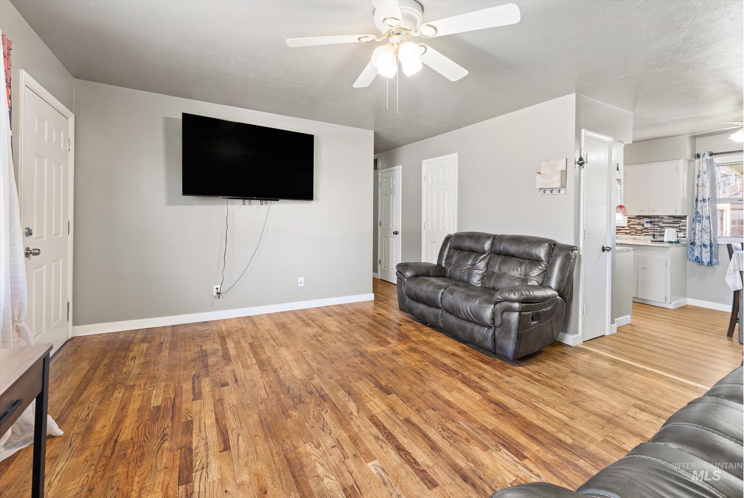 Living room featuring light wood-type flooring and ceiling fan