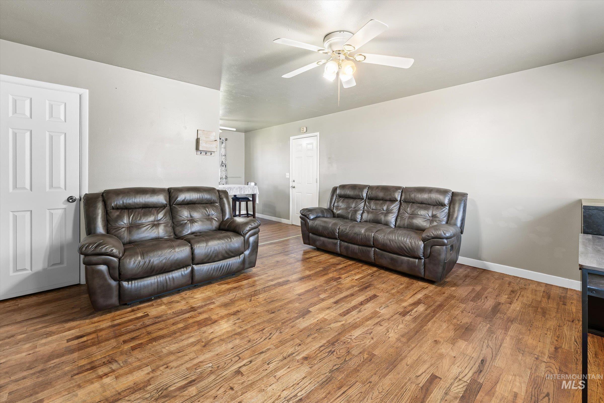 Living room with wood finished floors and a ceiling fan