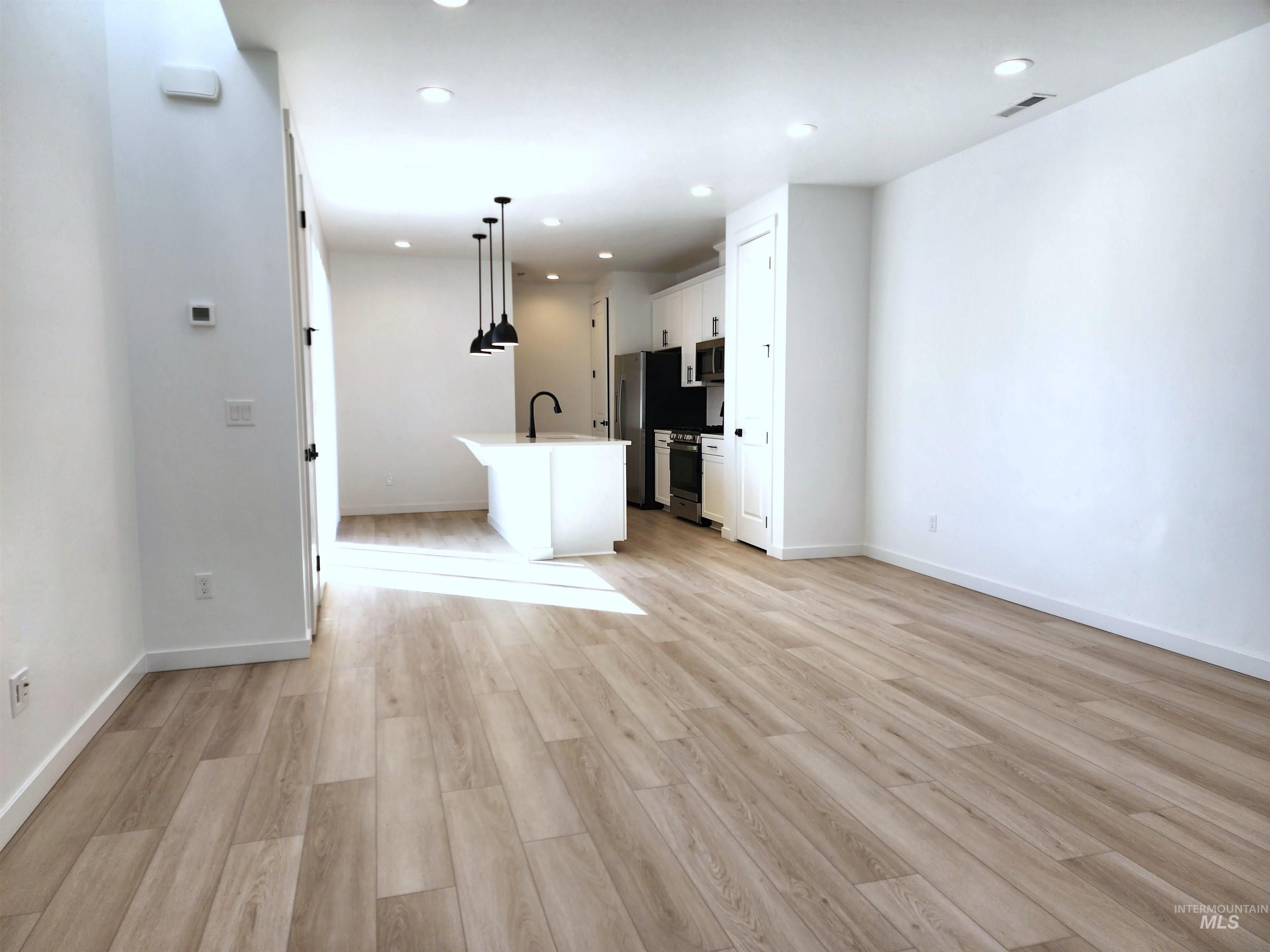 Unfurnished living room with light wood finished floors and recessed lighting