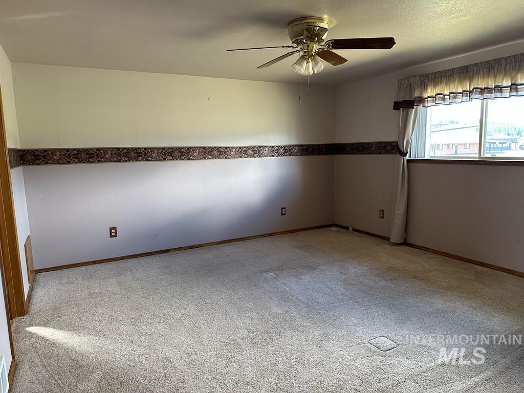 Spare room with ceiling fan and light carpet