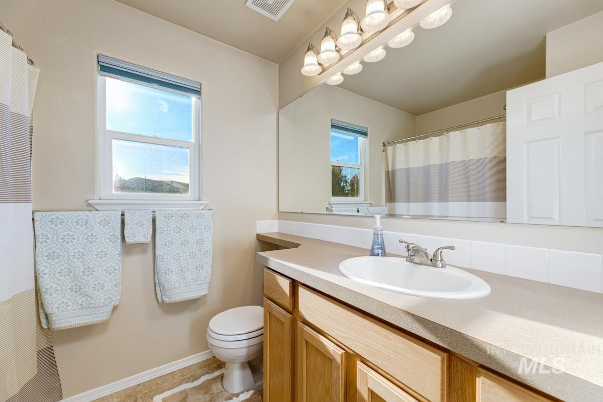 Bathroom featuring a shower with shower curtain, vanity, and a heating unit
