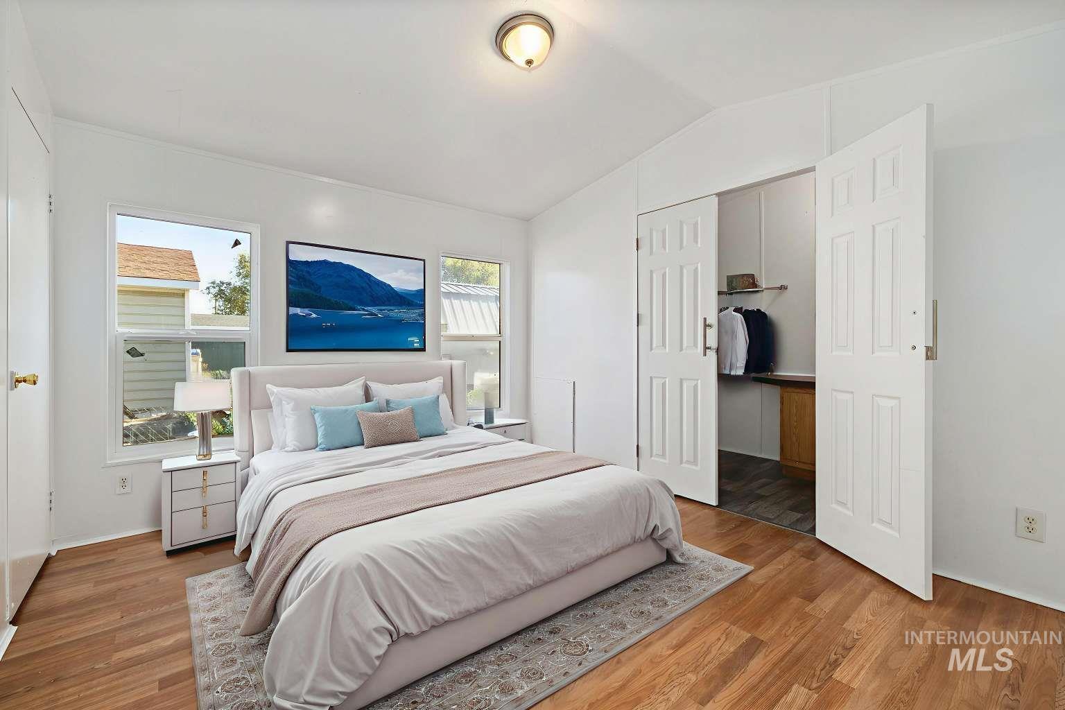 Bedroom with lofted ceiling, wood finished floors, and a closet