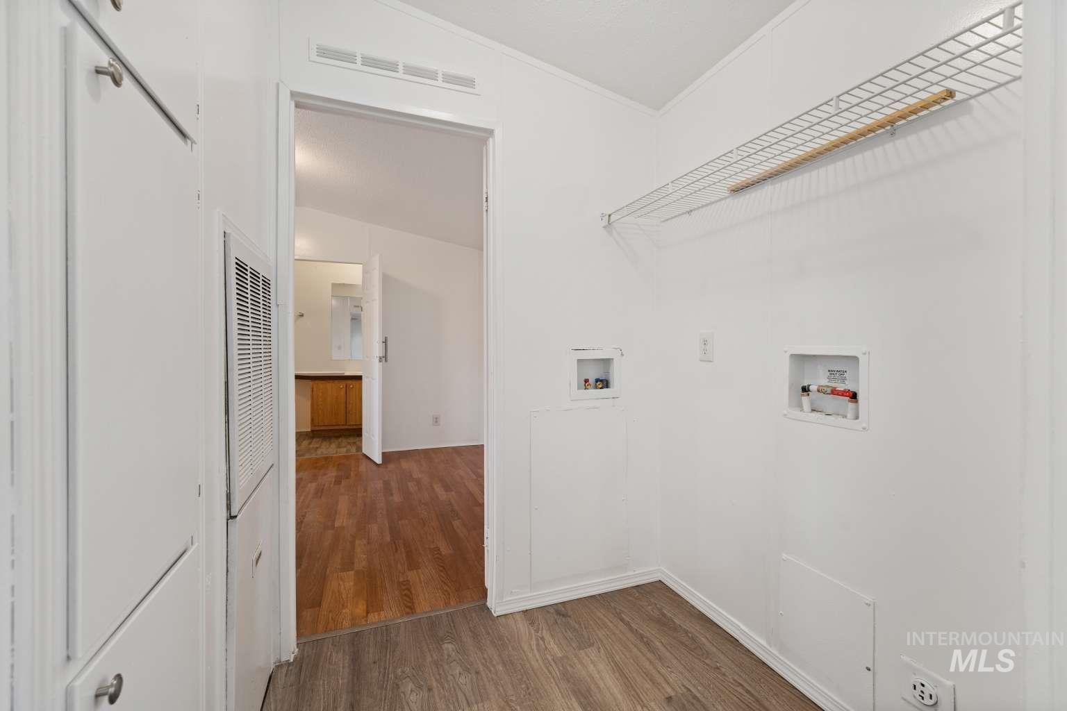 Laundry room featuring hookup for a washing machine, dark wood-style flooring, crown molding, and a heating unit