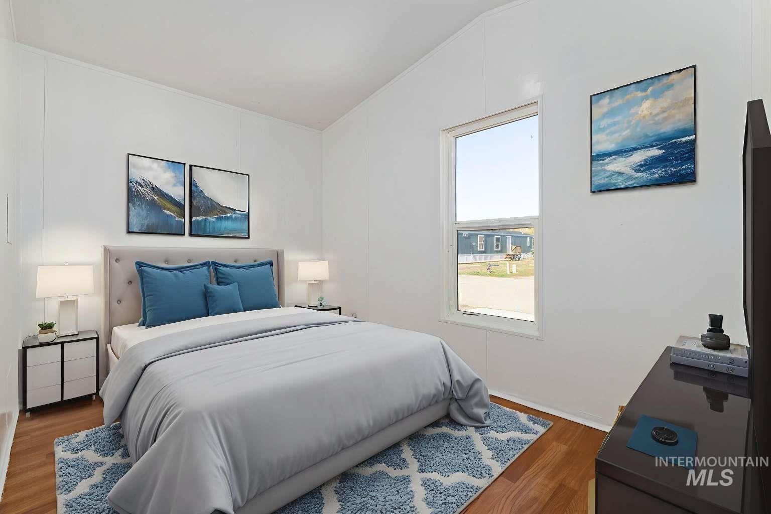 Bedroom featuring wood finished floors and vaulted ceiling