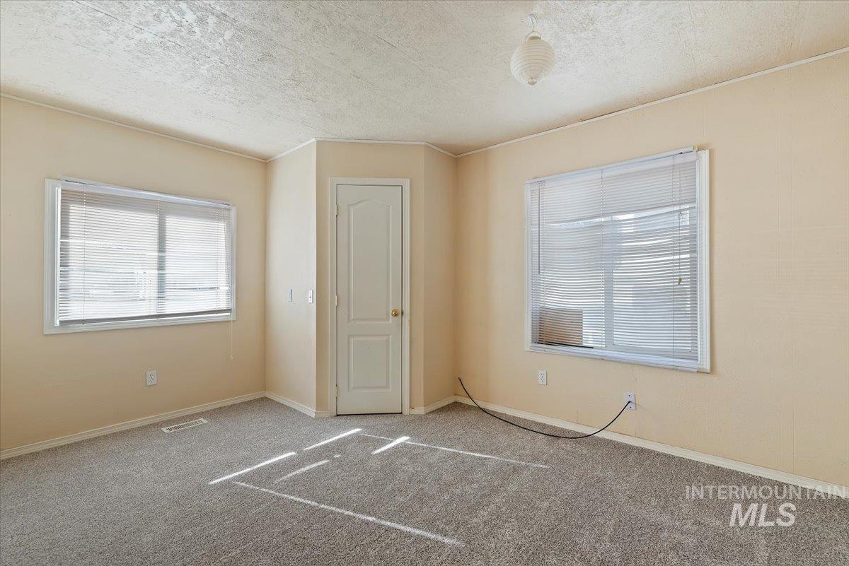 Unfurnished bedroom with a textured ceiling and carpet floors