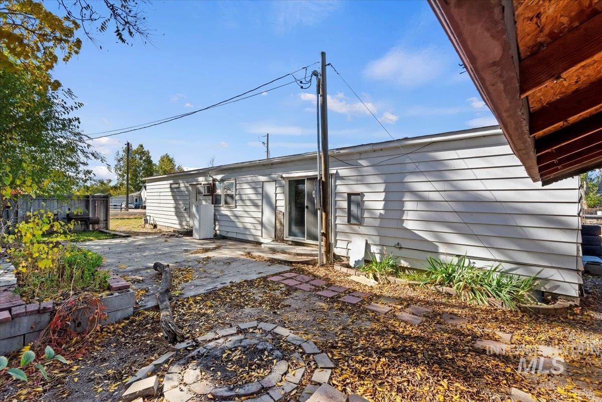 Rear view of property with a patio area and a fire pit