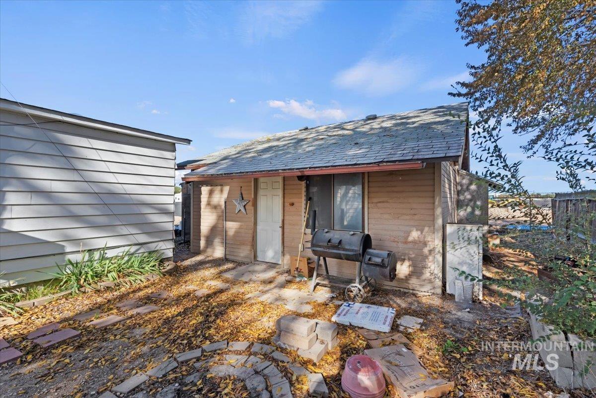Back of property with a fire pit and an outbuilding