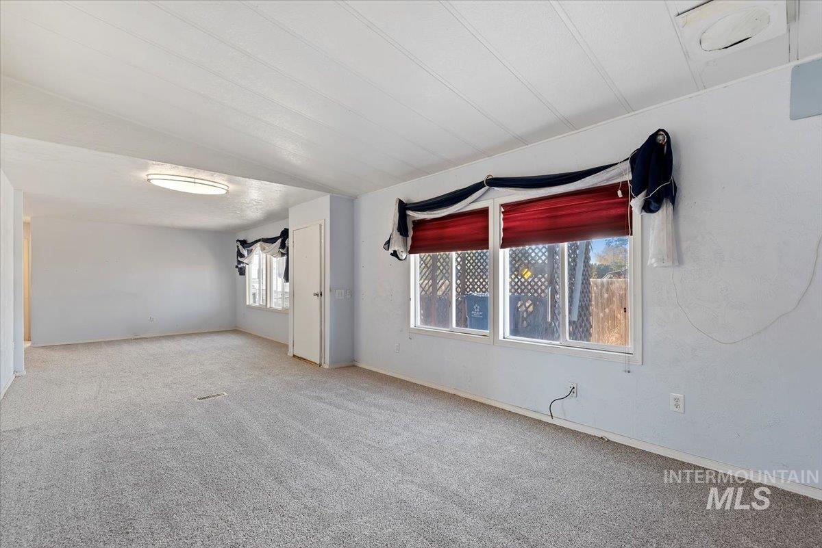 Carpeted spare room with baseboards