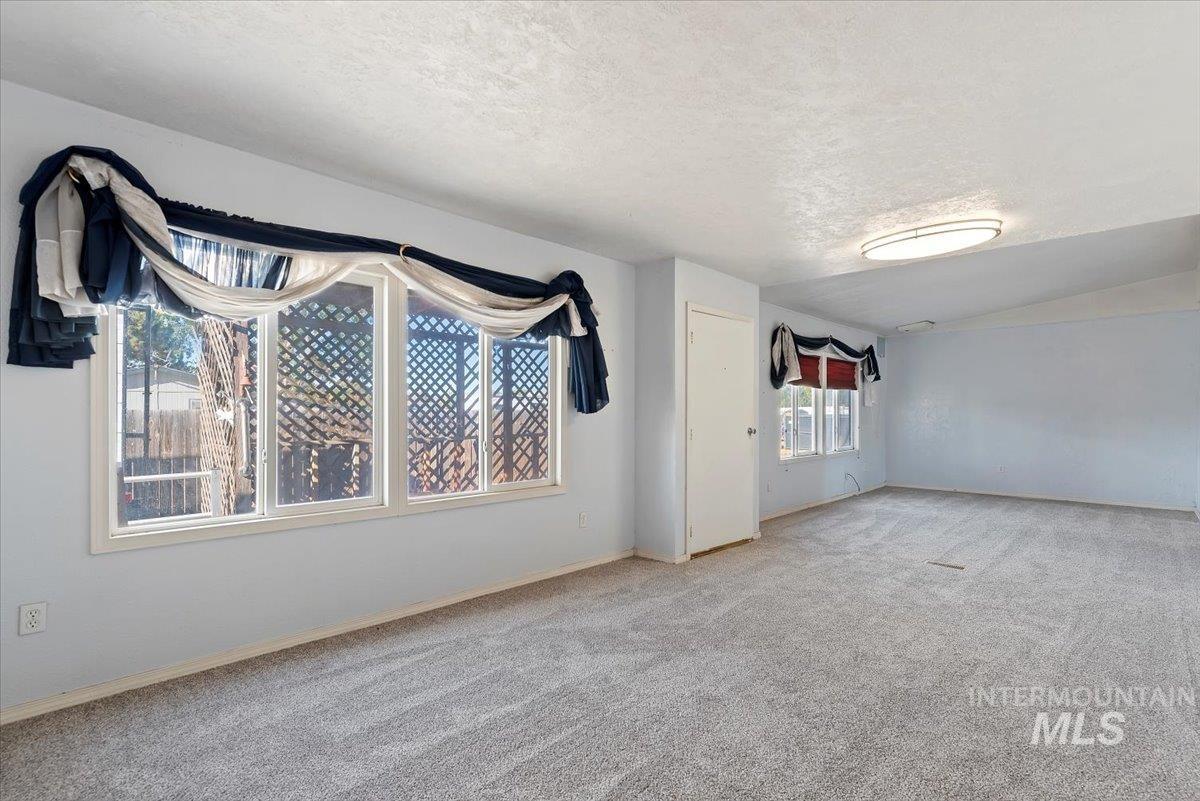 Unfurnished room featuring carpet floors and a textured ceiling