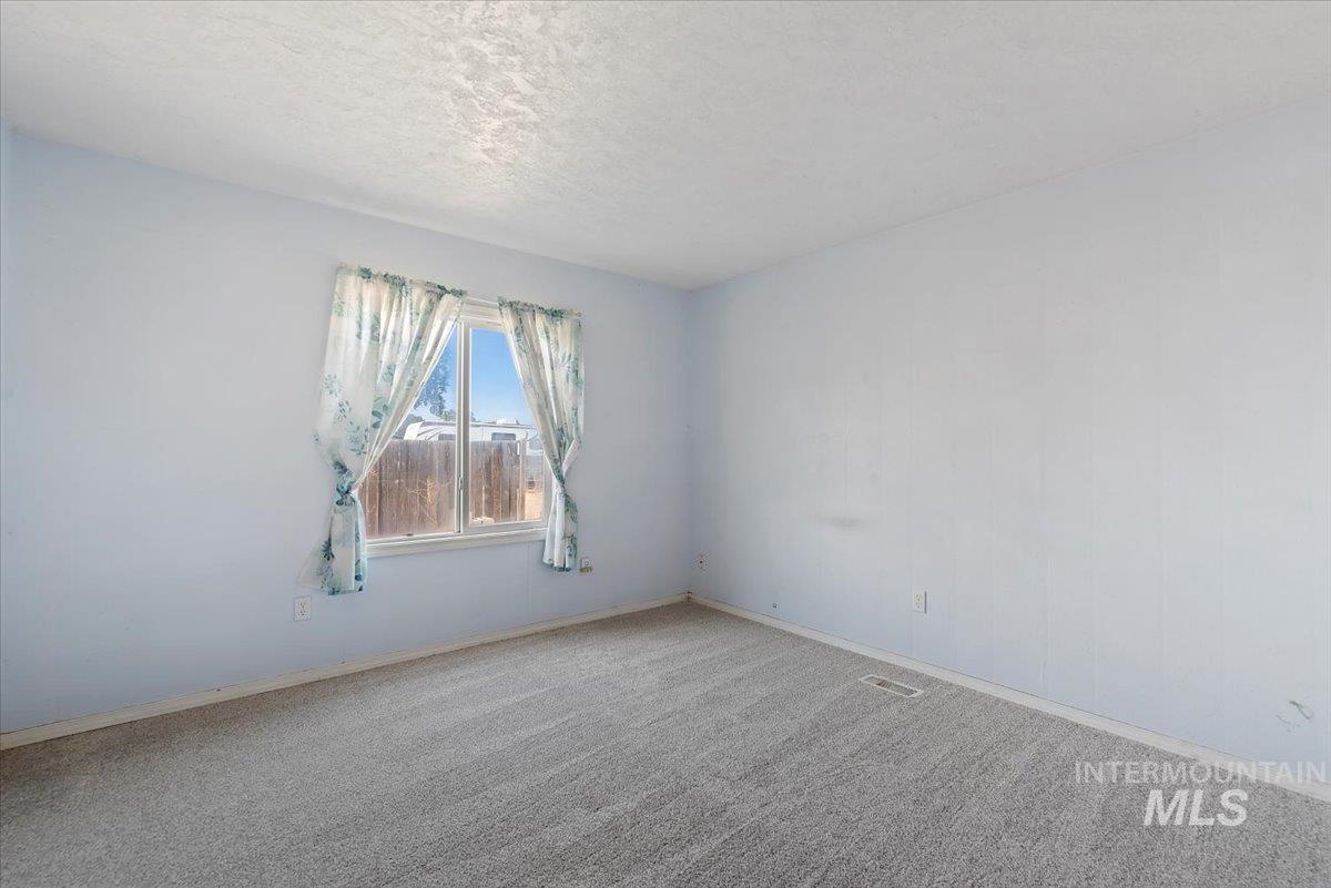 Spare room featuring carpet floors and a textured ceiling