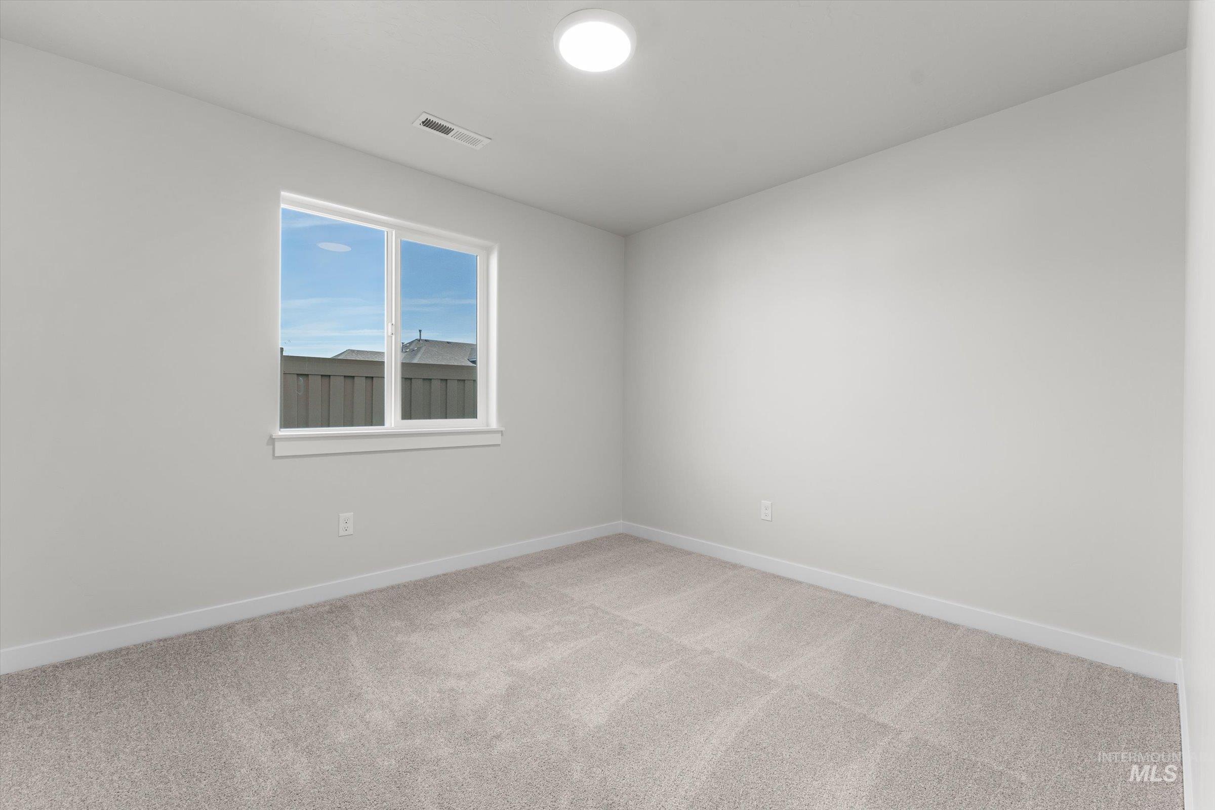 Carpeted empty room with baseboards