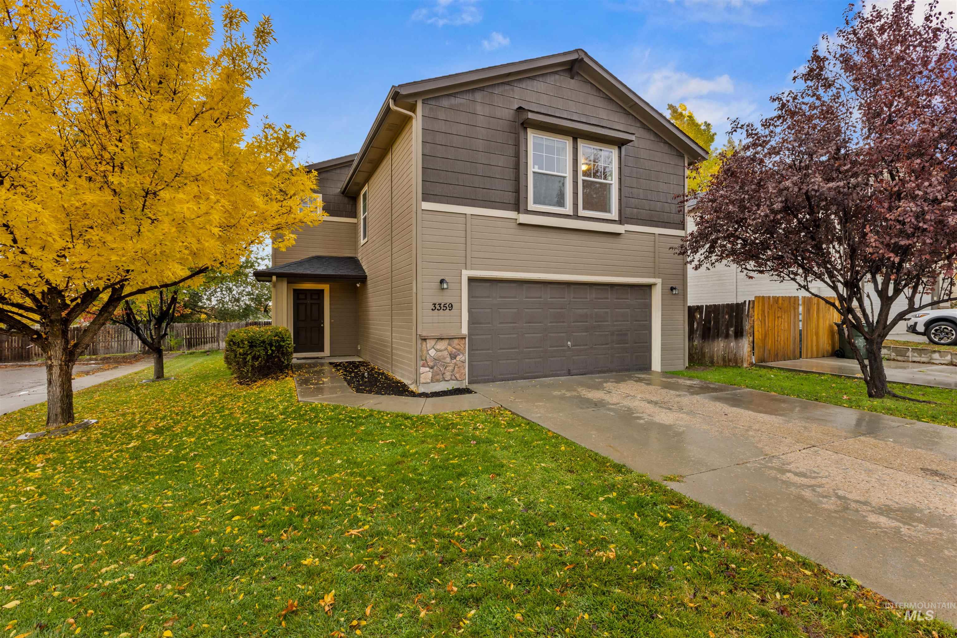 Traditional home featuring concrete driveway, stone siding, and an attached garage