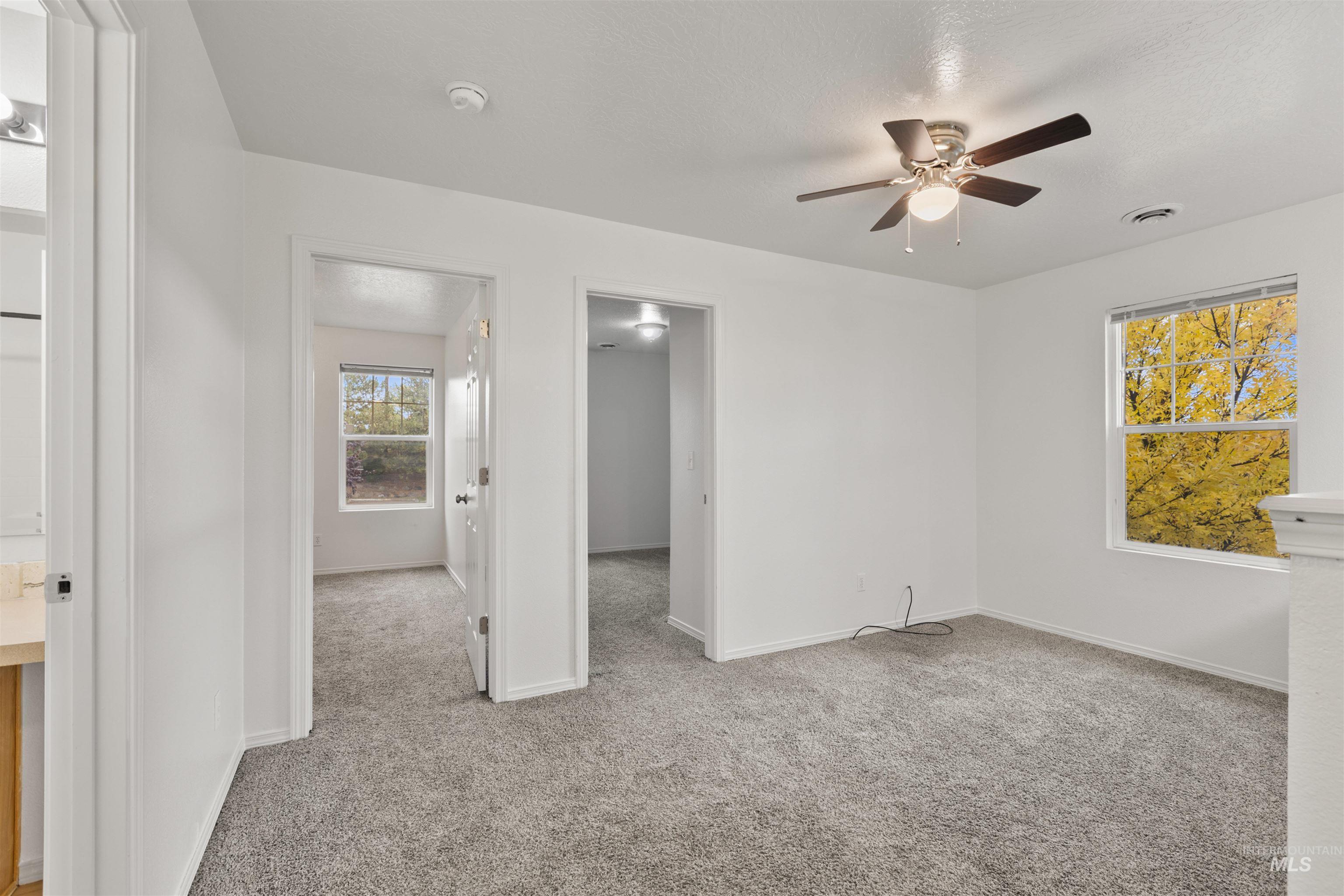 Spare room featuring light carpet and ceiling fan