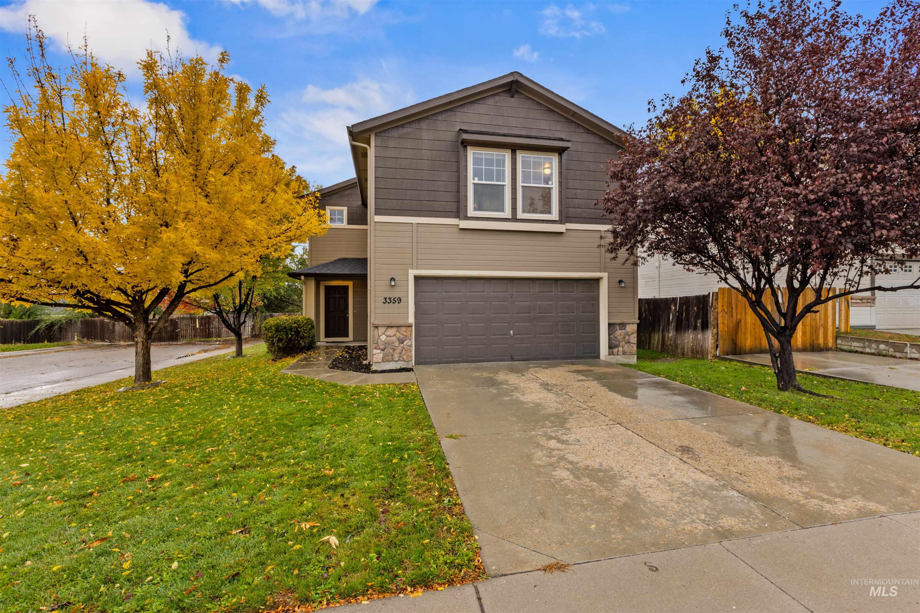 View of front of house with stone siding, concrete driveway, and an attached garage
