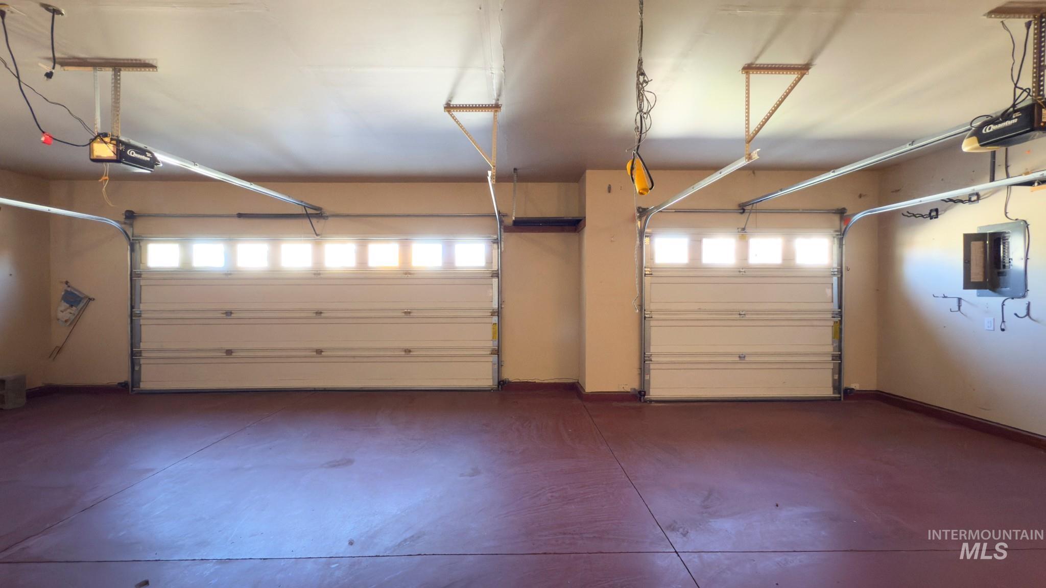 Garage featuring electric panel and a garage door opener