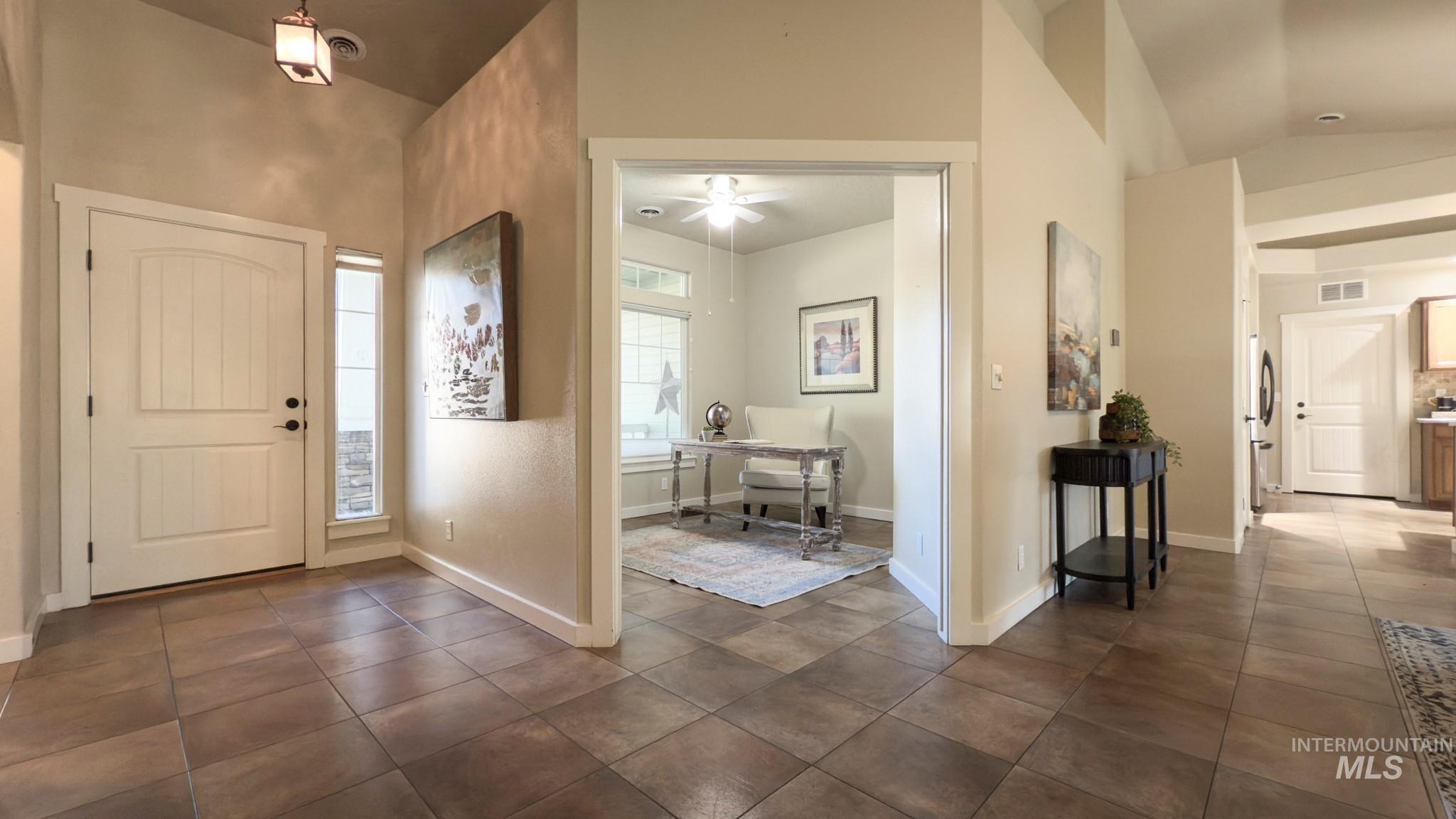 Entryway with dark tile patterned floors and ceiling fan