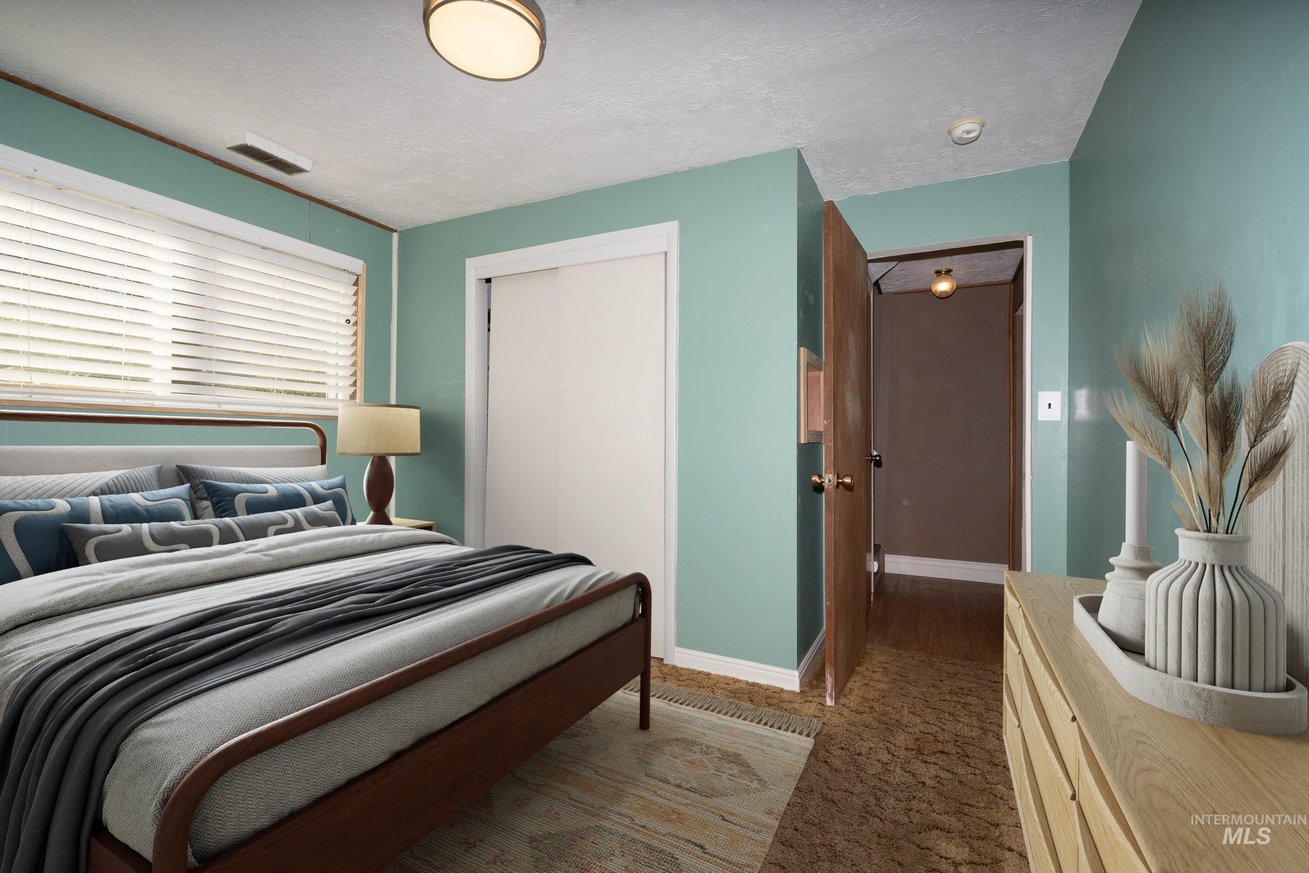 Bedroom with a textured ceiling and a closet