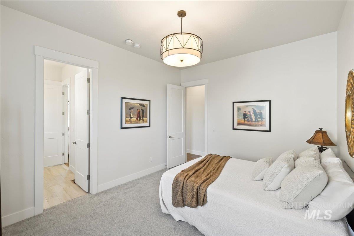 Bedroom featuring light carpet and baseboards