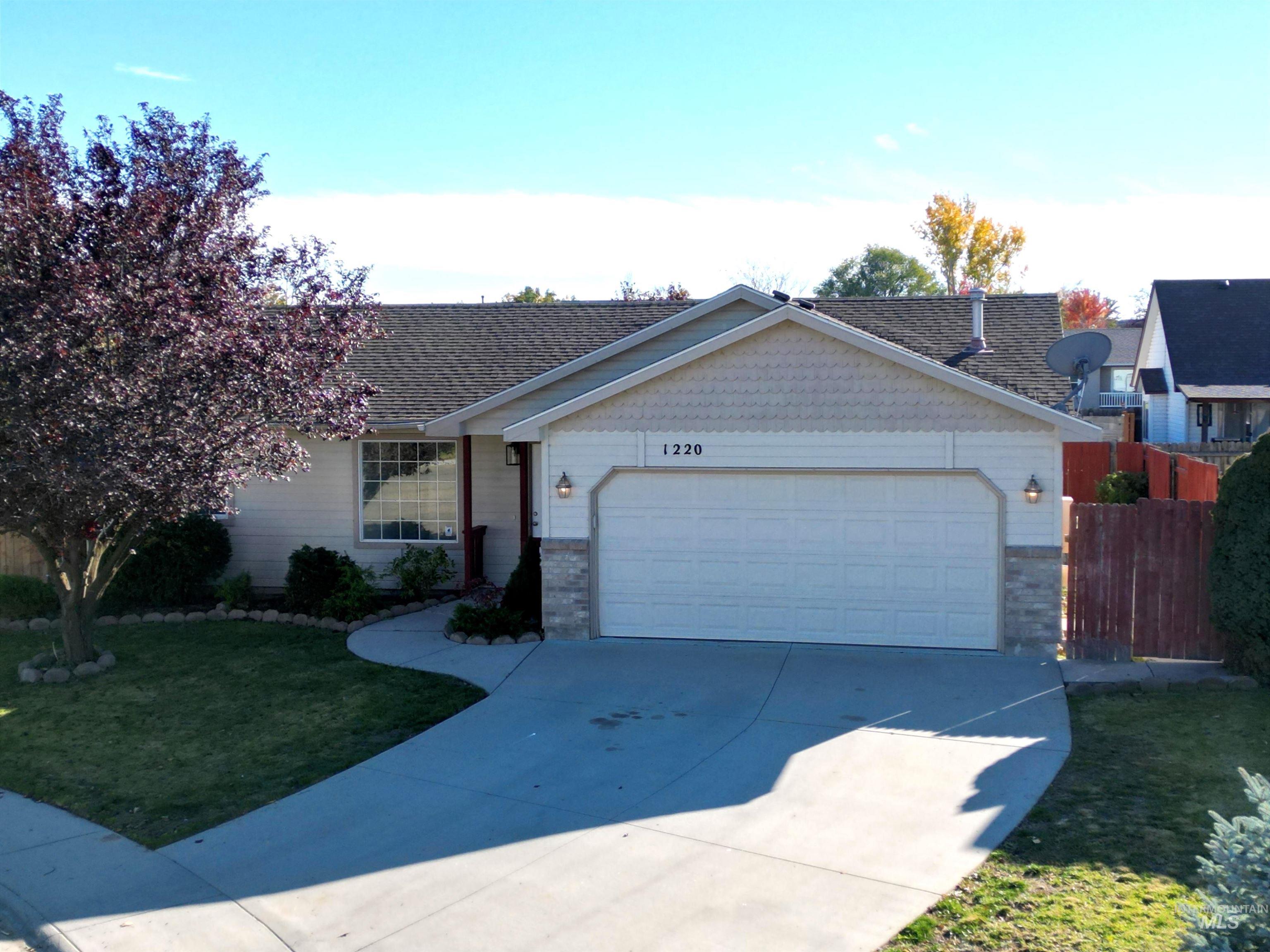 Ranch-style home with brick siding, concrete driveway, an attached garage, and a shingled roof