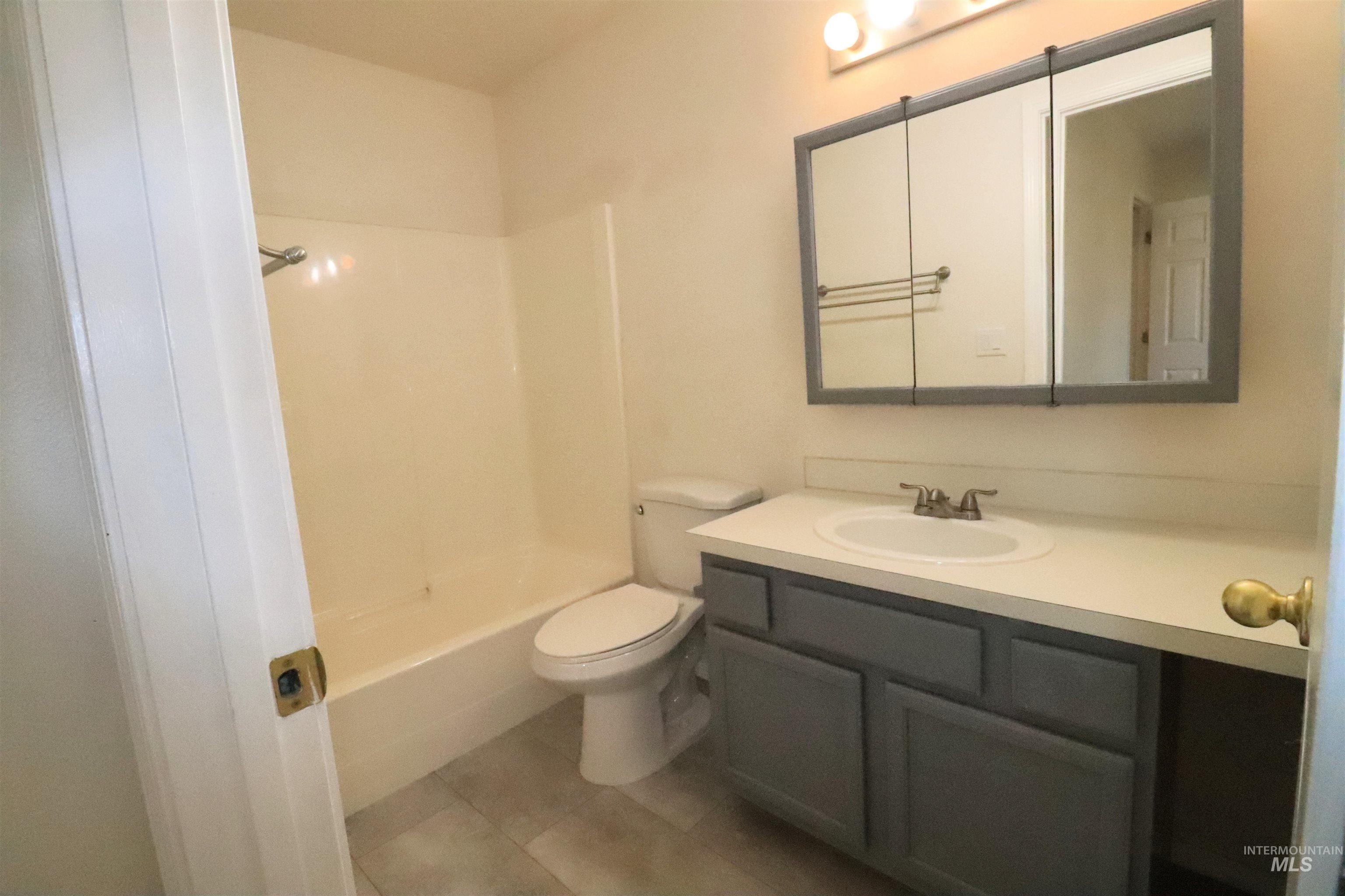 Full bath with vanity,  shower combination, and light tile patterned flooring