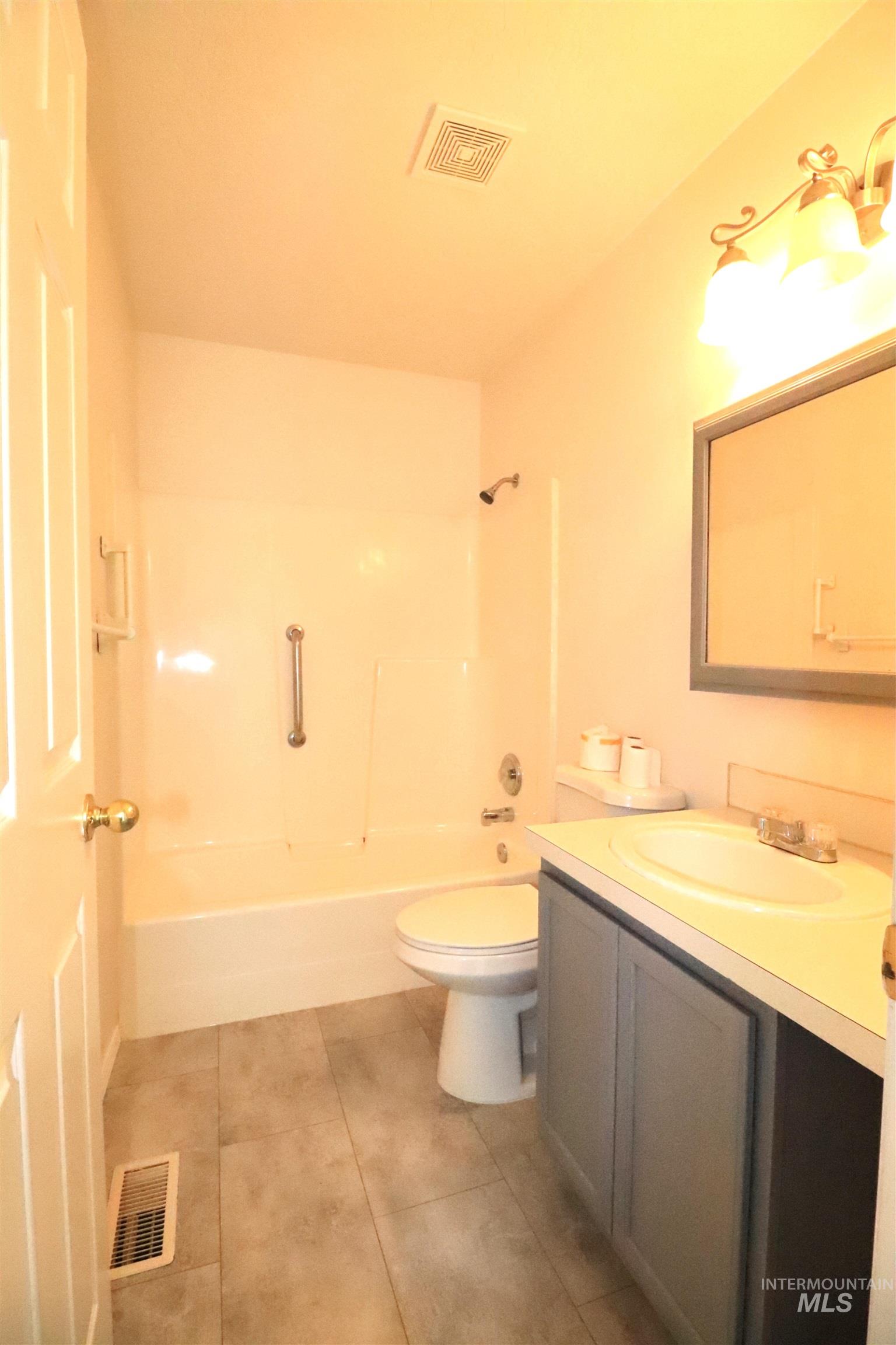 Full bath featuring vanity, washtub / shower combination, and light tile patterned flooring