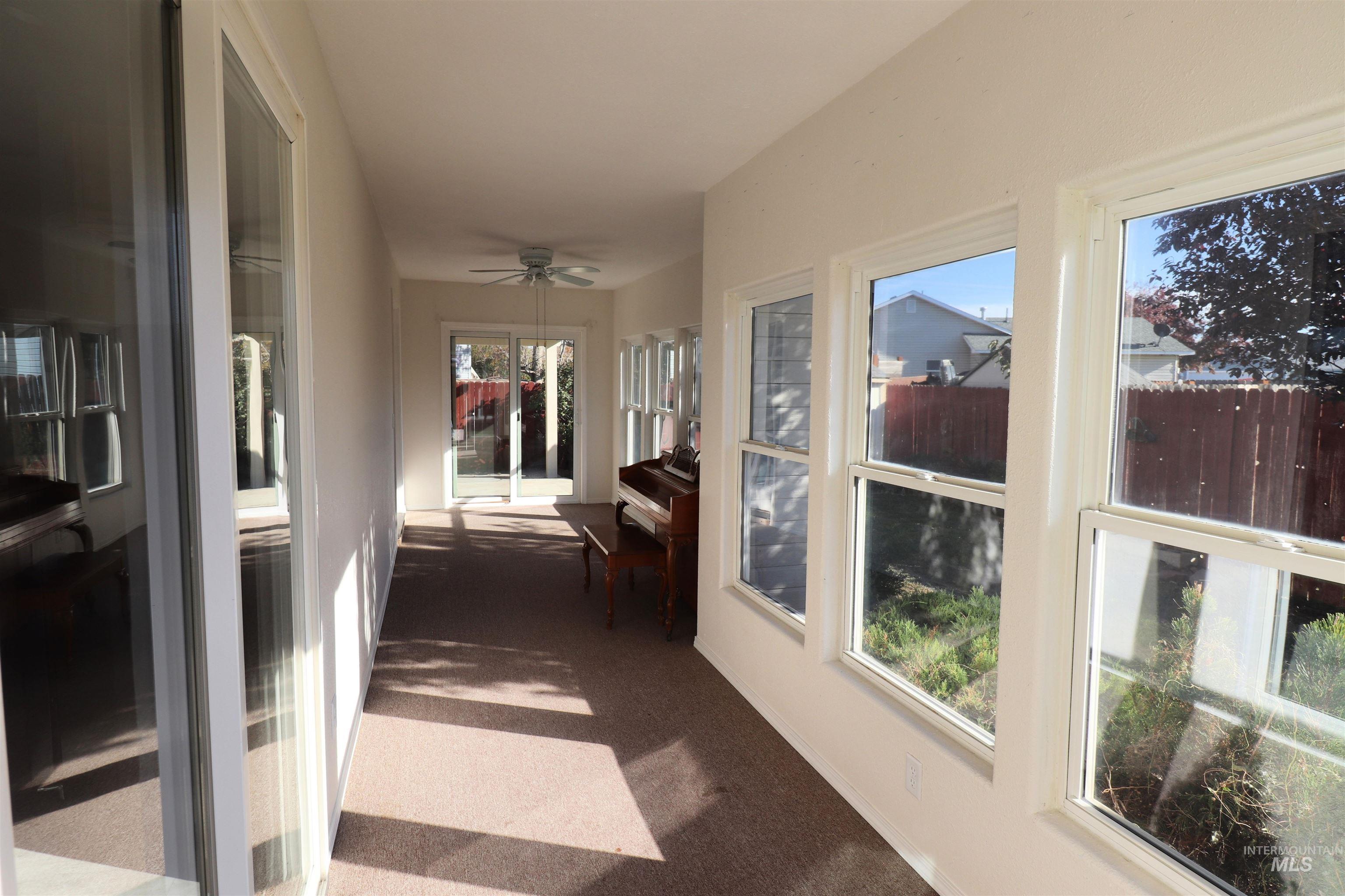Sunroom / solarium featuring carpet and baseboards