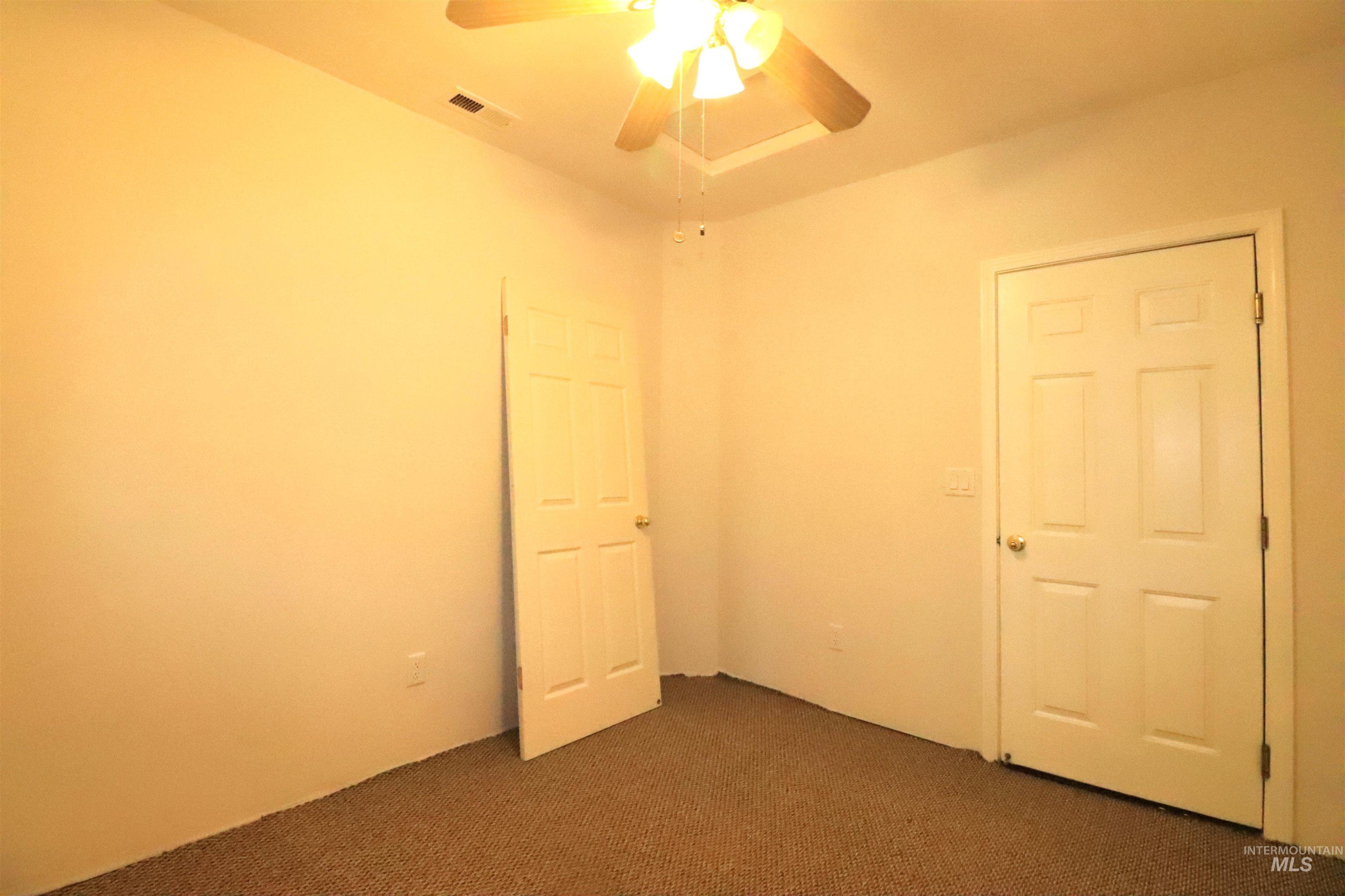 Office with dark carpet and ceiling fan