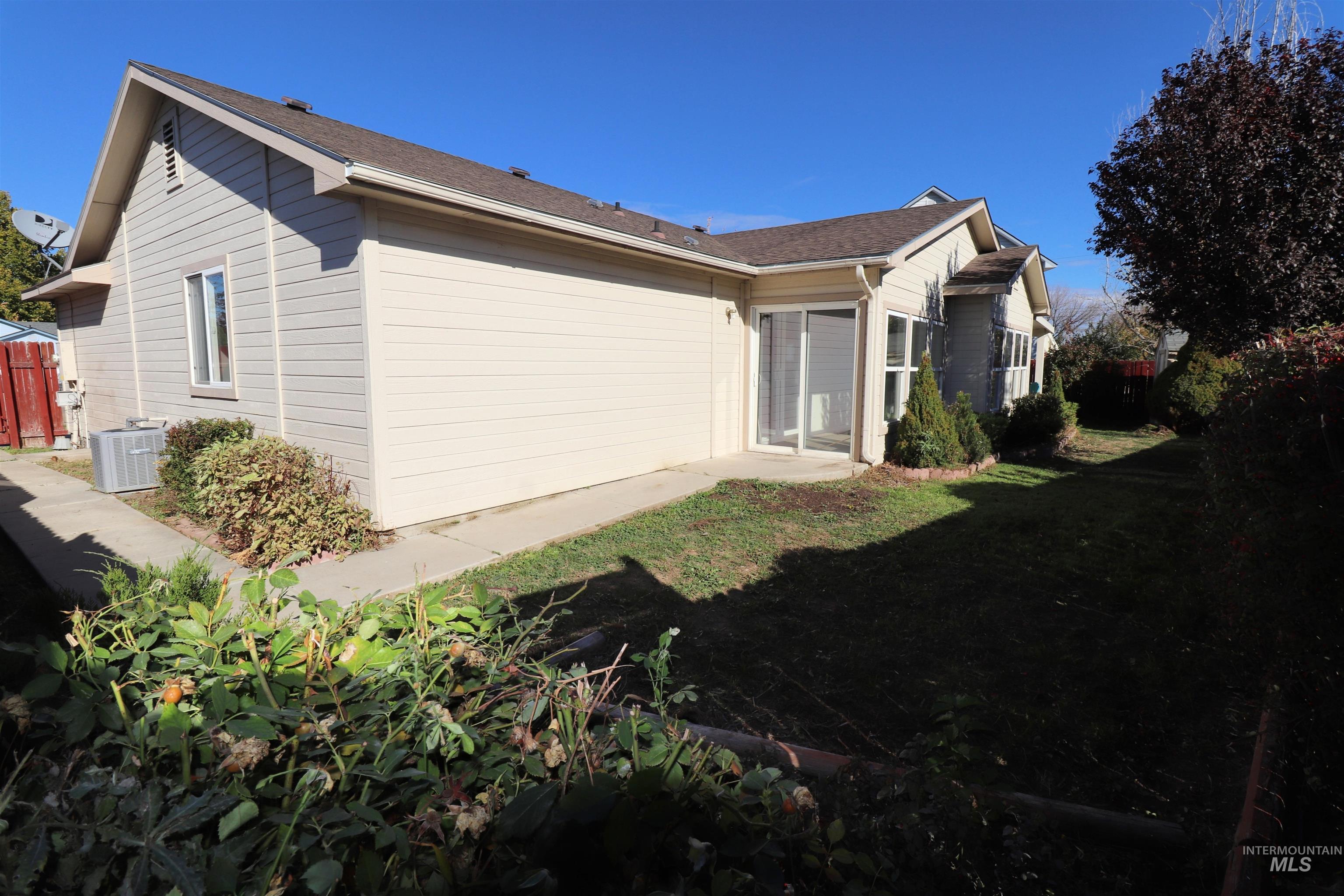 View of home's exterior with a yard and roof with shingles