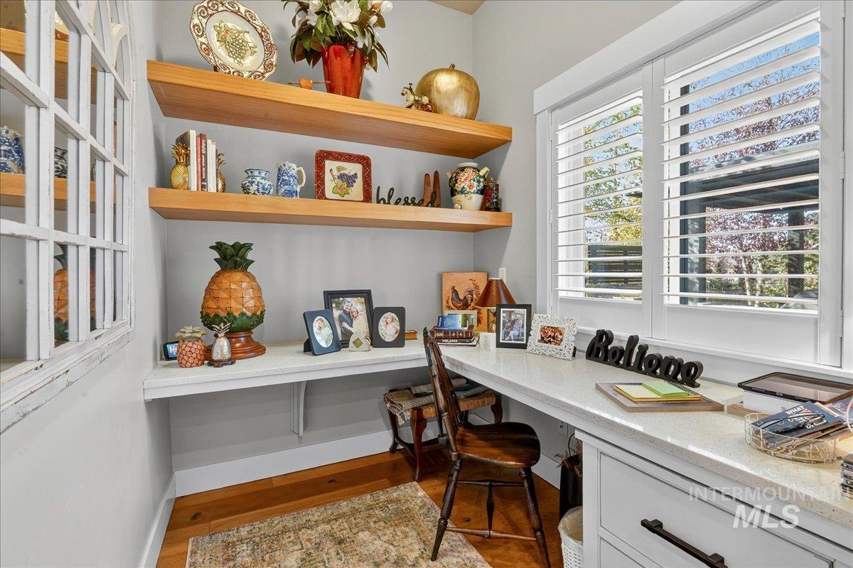 Home office with built in study area and light wood finished floors
