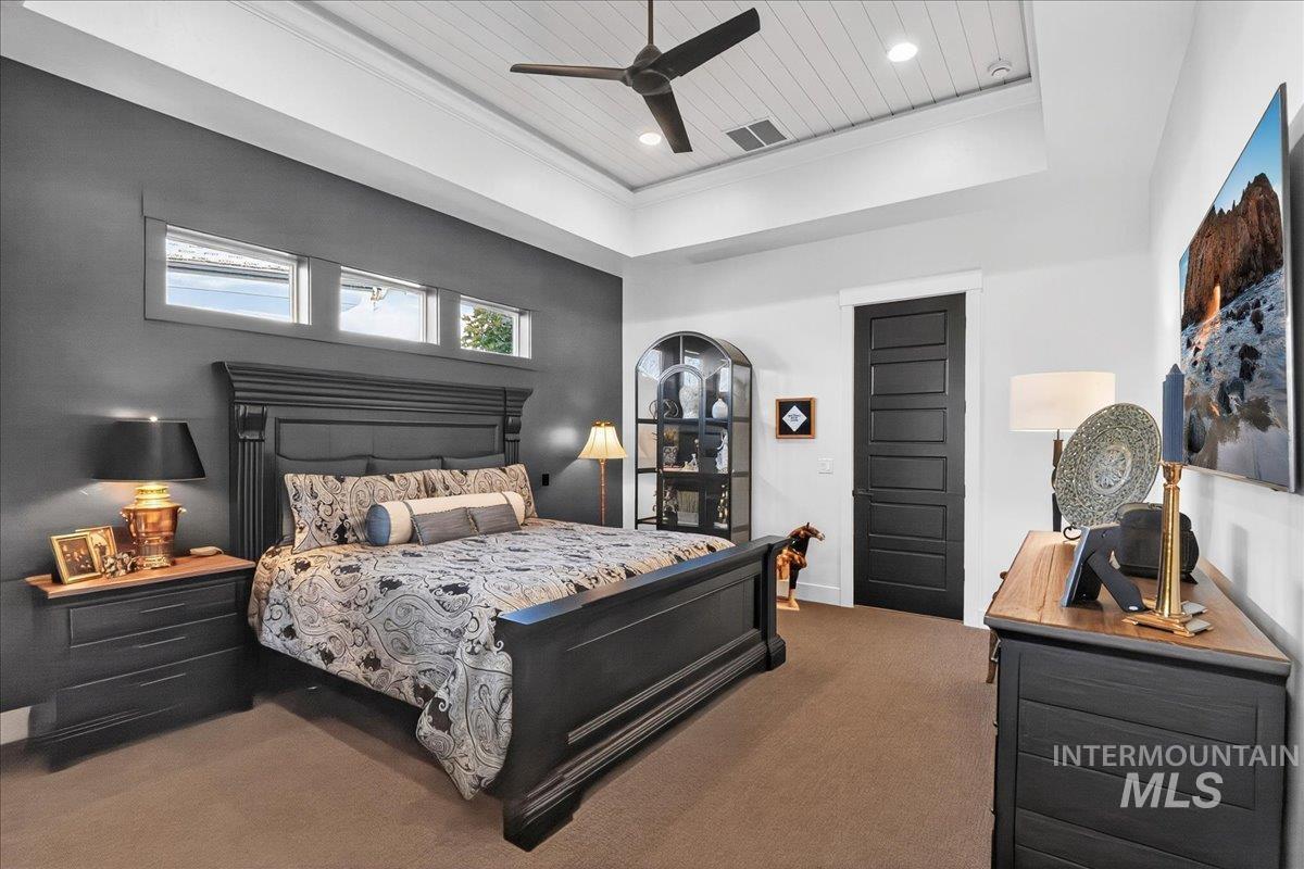 Bedroom featuring ornamental molding, carpet, a tray ceiling, ceiling fan, and recessed lighting