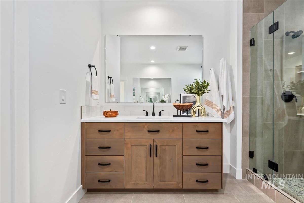 Full bath with vanity, a stall shower, light tile patterned floors, and recessed lighting