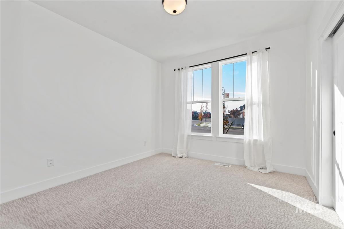 Unfurnished room featuring light colored carpet and baseboards