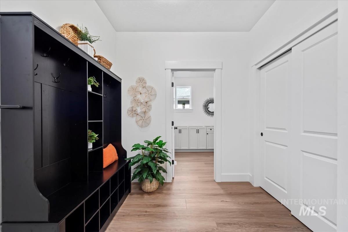 Mudroom featuring light wood-style flooring and baseboards