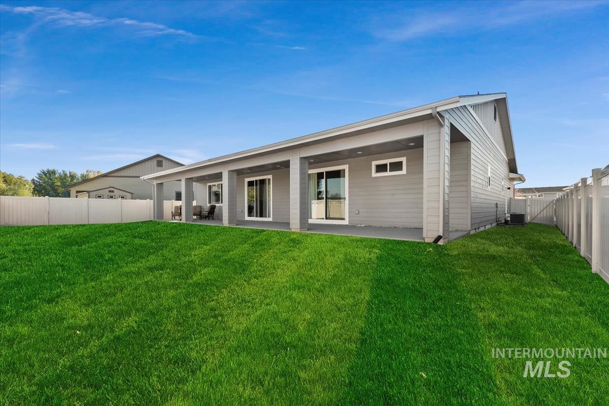 Rear view of house with a fenced backyard and a patio area