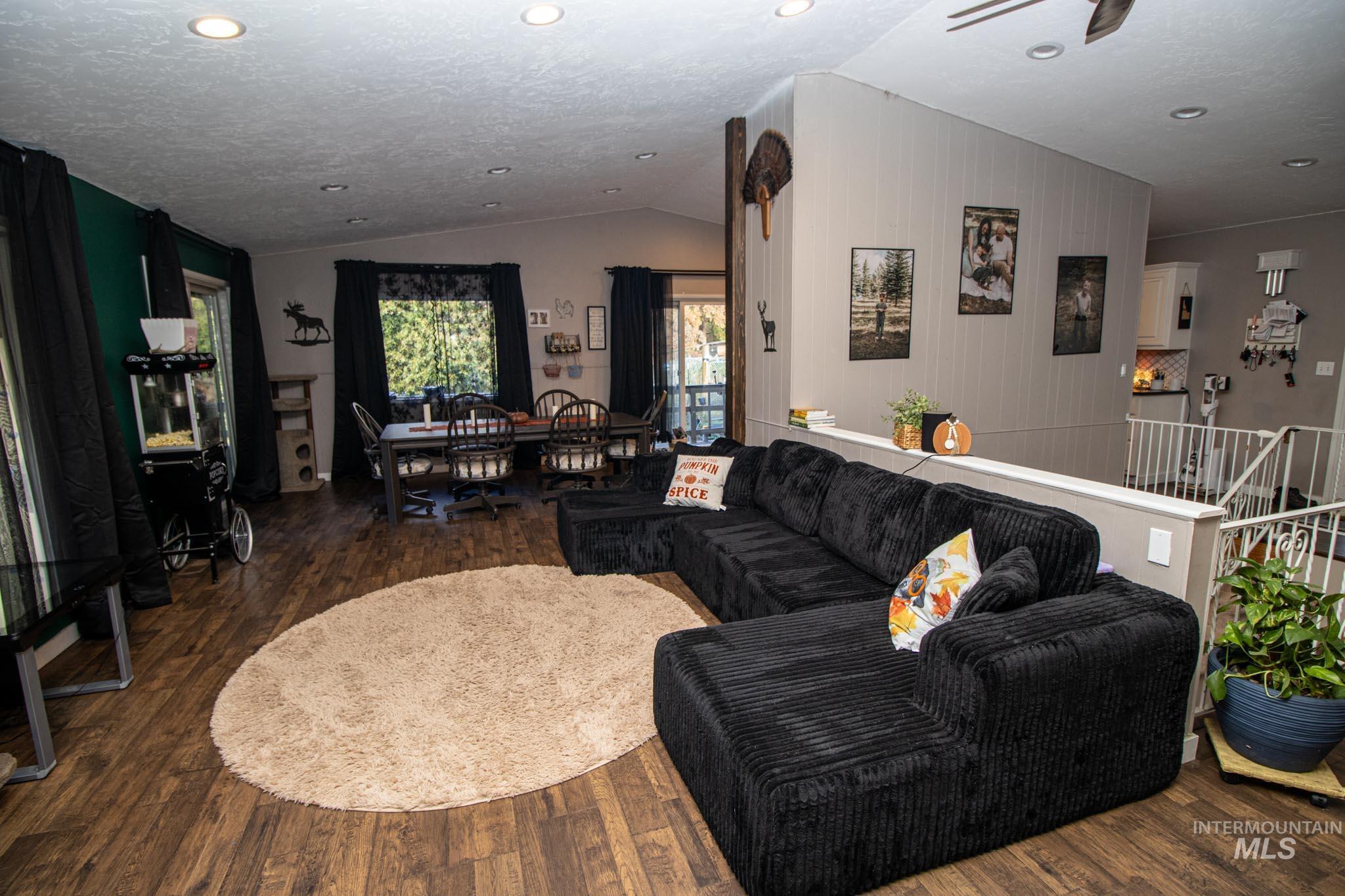 Living area with wood finished floors, lofted ceiling, and recessed lighting
