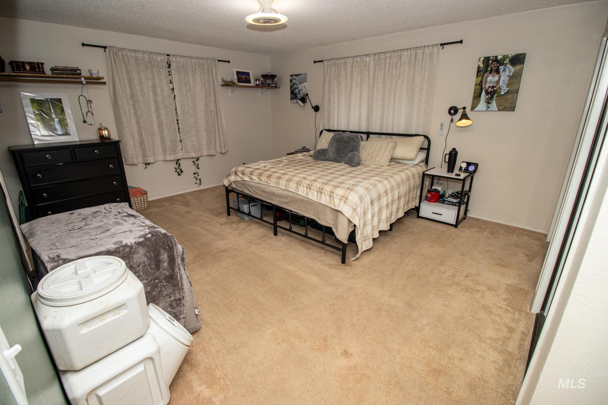 Bedroom featuring light carpet and a textured ceiling