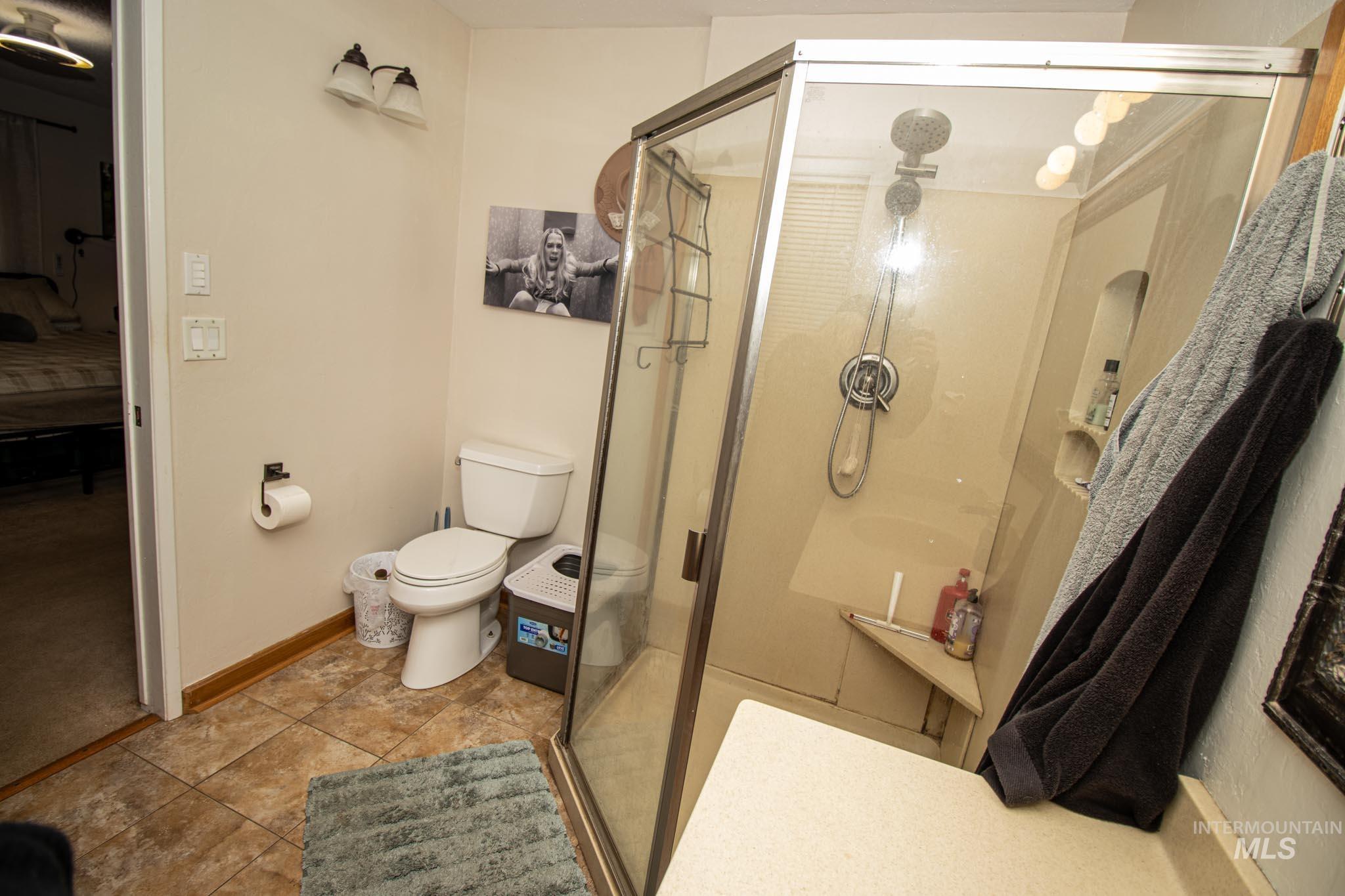 Full bath featuring a stall shower and light tile patterned floors