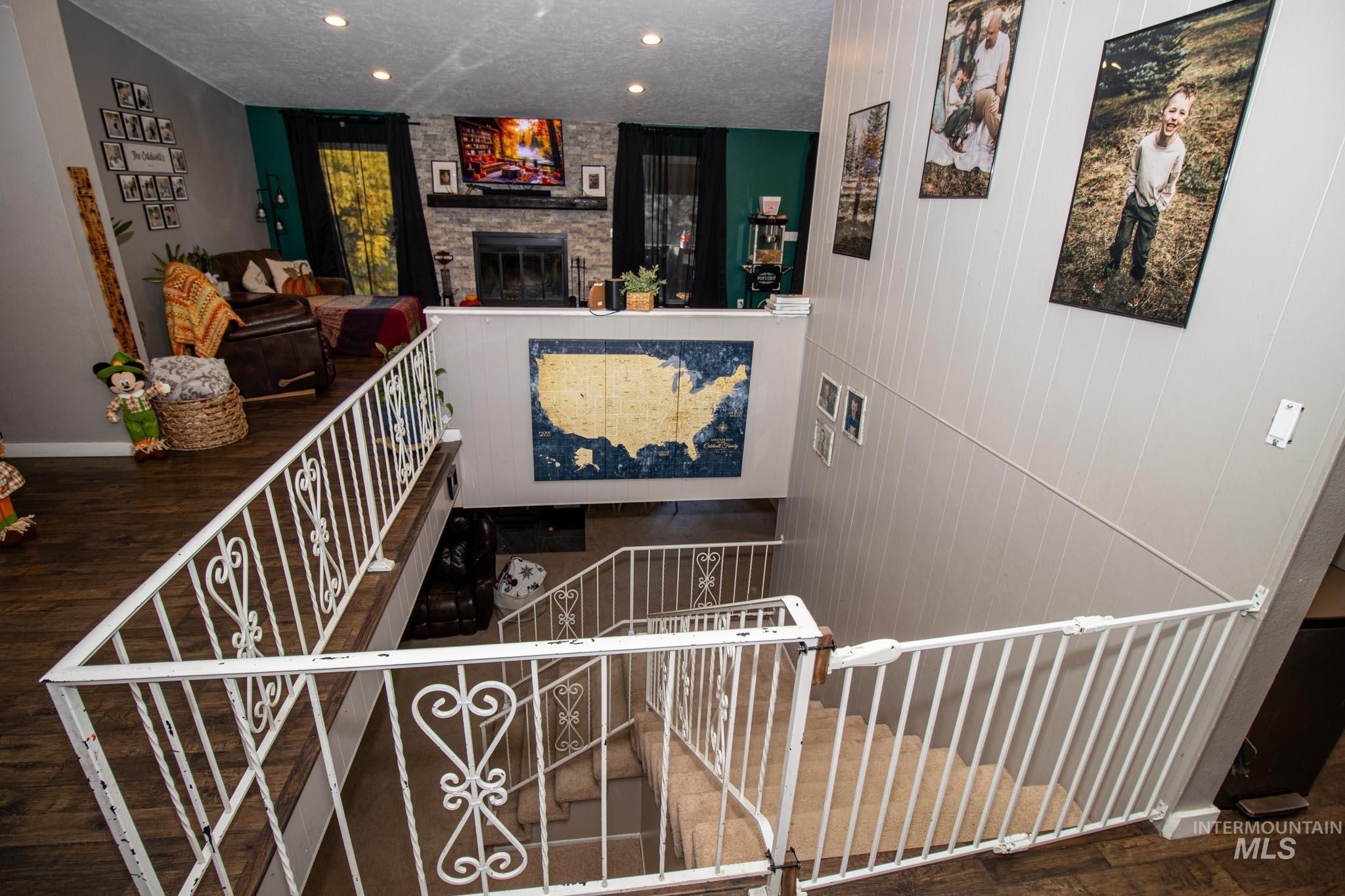 Stairway featuring wood finished floors, a fireplace, a textured ceiling, and recessed lighting