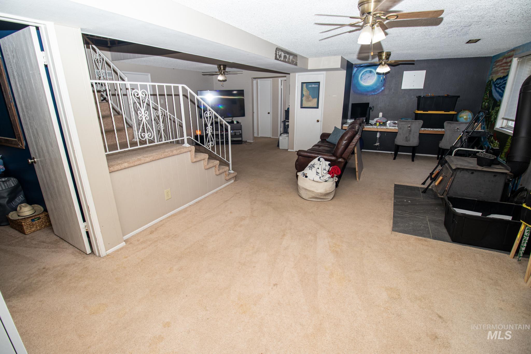 Office with a ceiling fan, carpet, and a textured ceiling