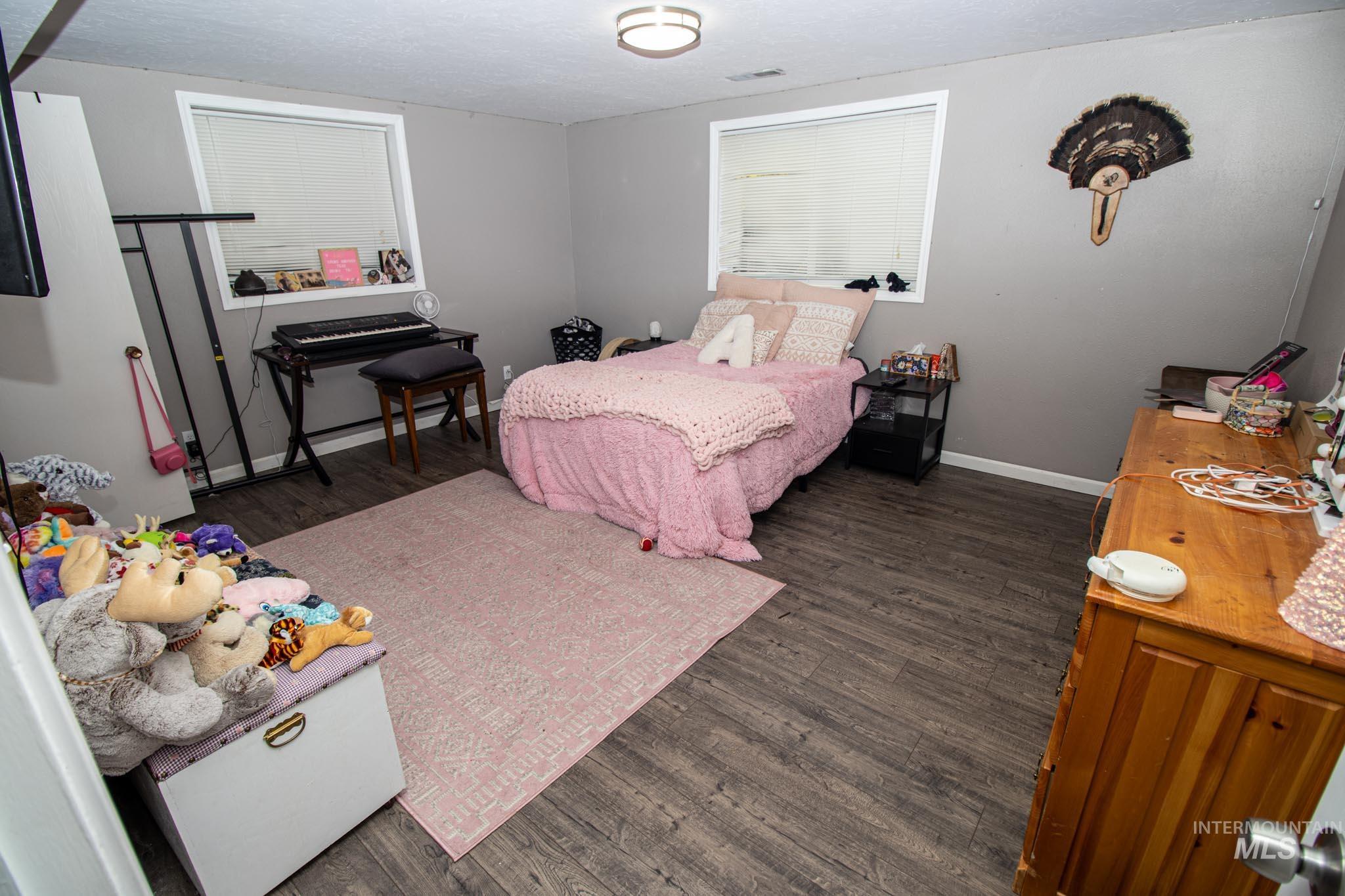 Bedroom with dark wood-style floors and a textured ceiling