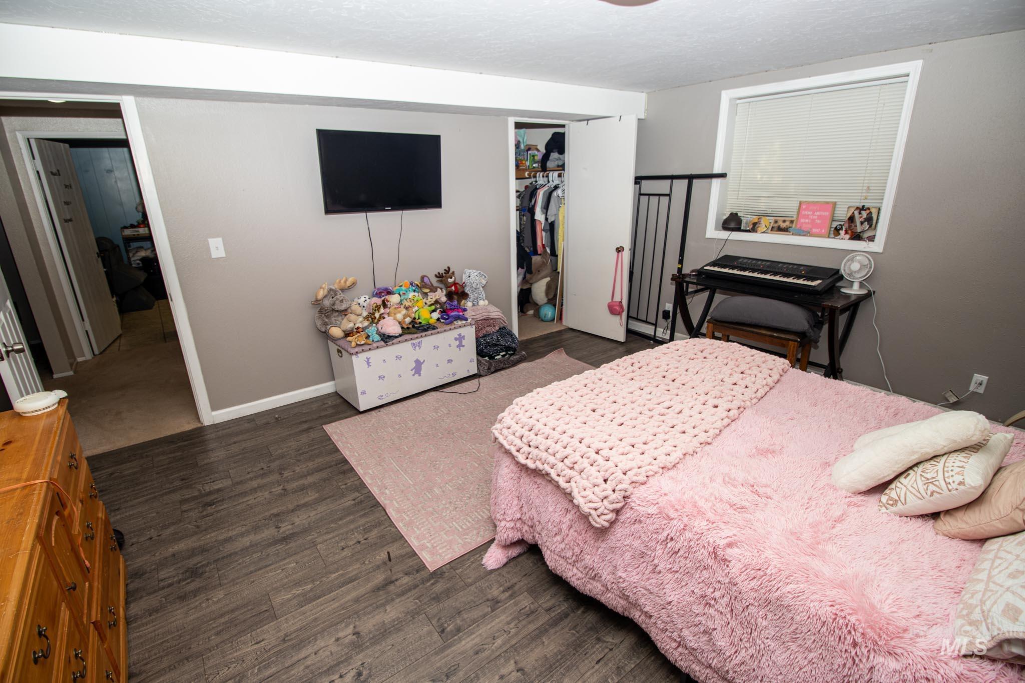 Bedroom featuring a closet, dark wood-type flooring, and a textured ceiling