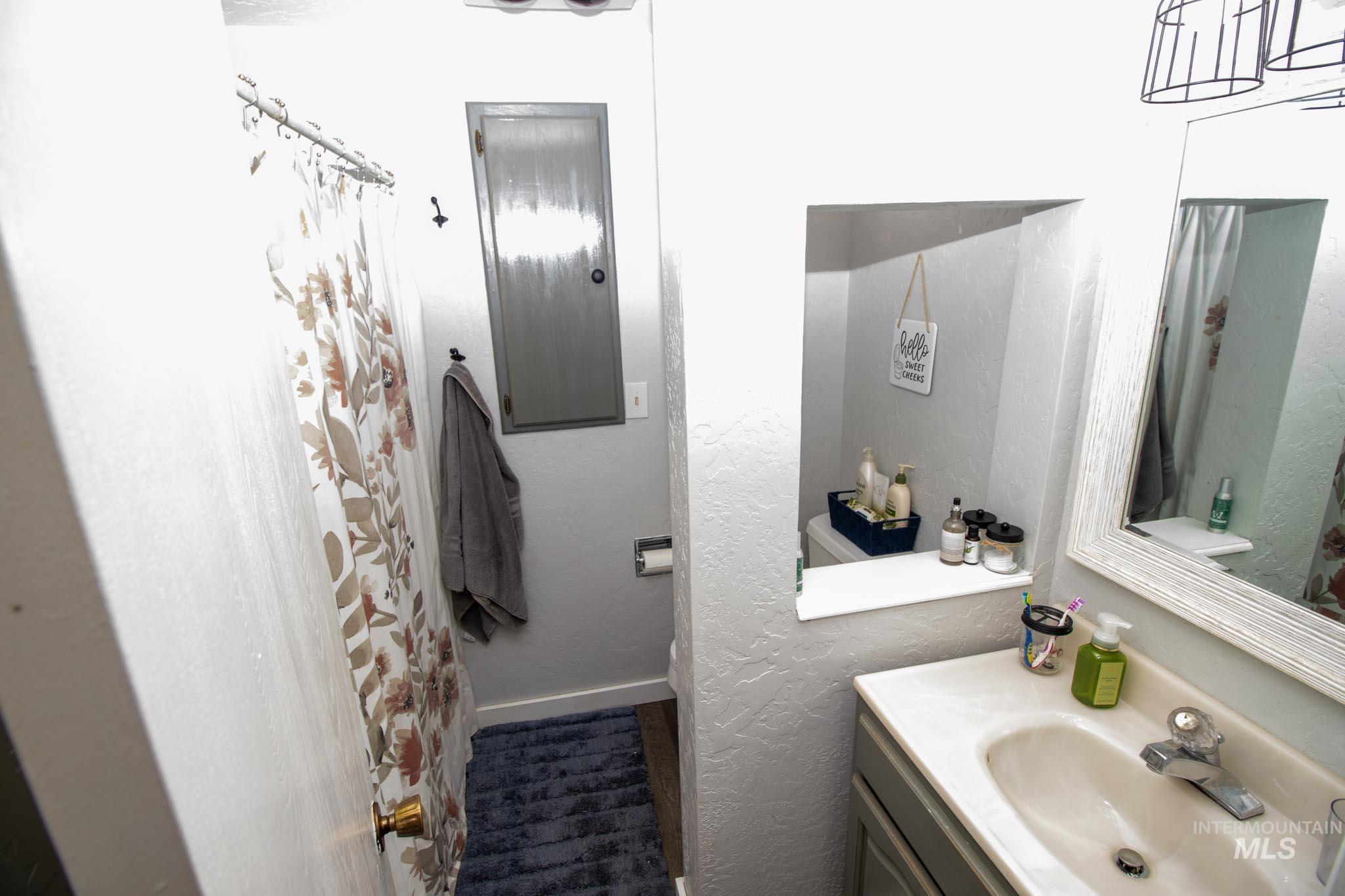 Bathroom featuring vanity, a shower with shower curtain, and a textured wall