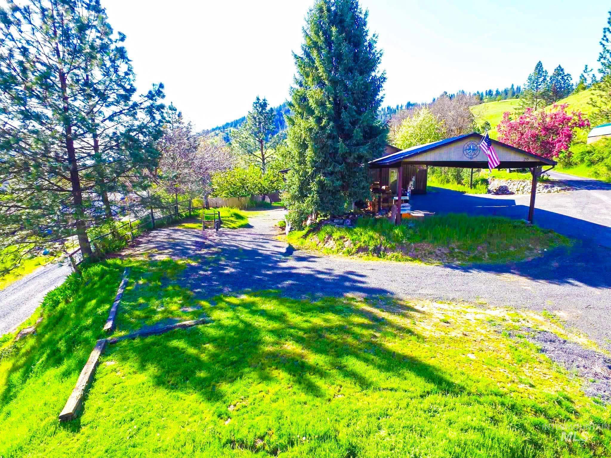View of dirt / gravel driveway, carport