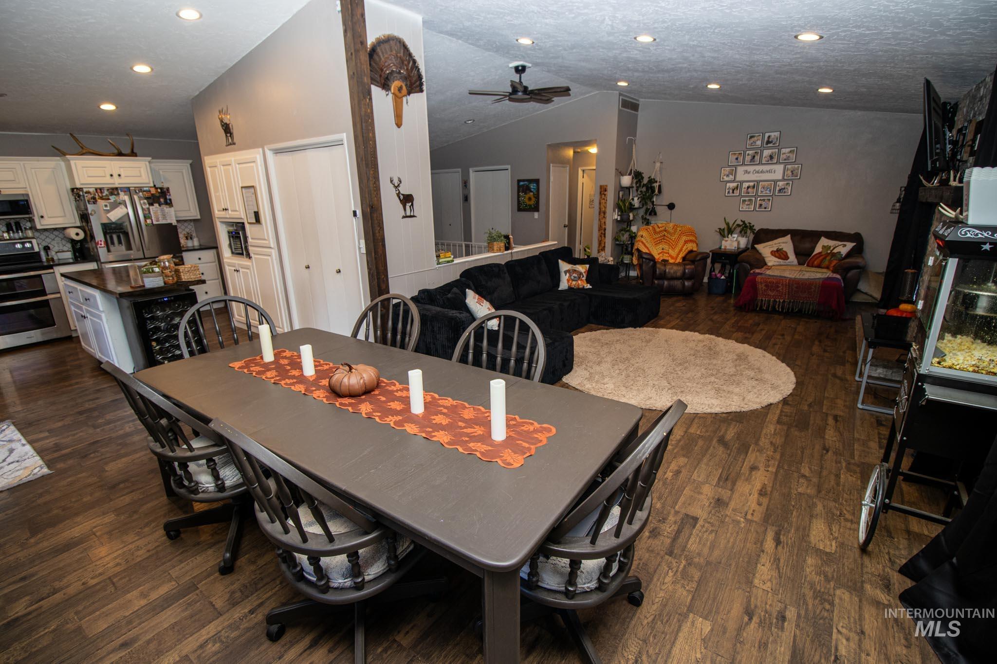 Dining room with lofted ceiling, recessed lighting, ceiling fan, a textured ceiling, and dark wood-type flooring
