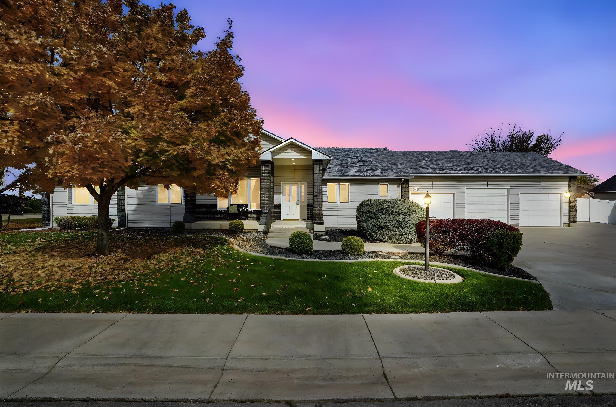 View of front facade with a lawn, concrete driveway, and a garage