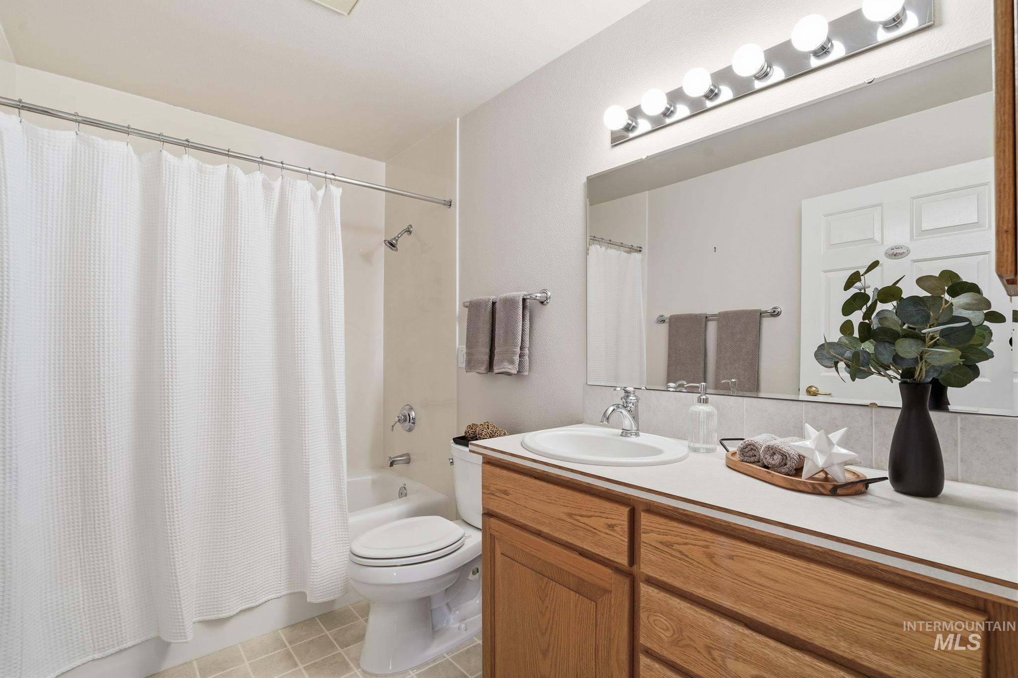 Full bath featuring shower / bath combo, light tile patterned flooring, and vanity