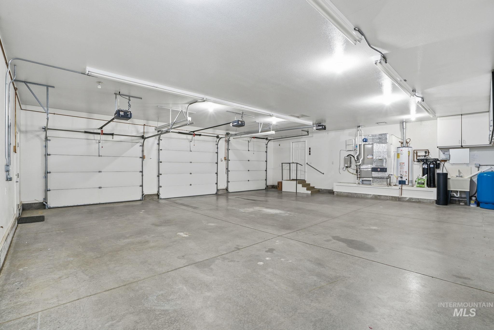 Garage featuring water heater and a garage door opener