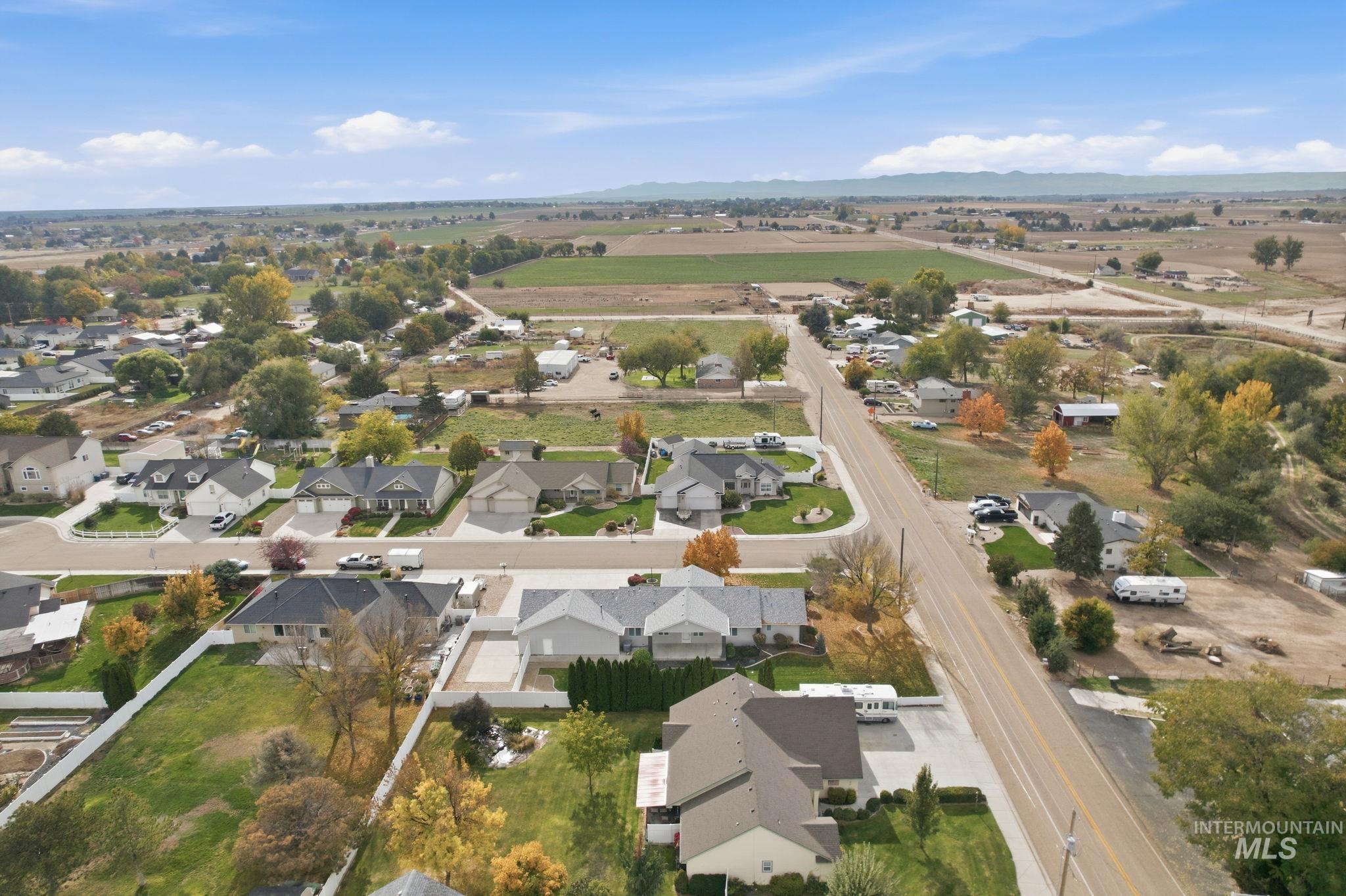 Aerial view of property and surrounding area featuring nearby suburban area and mountains