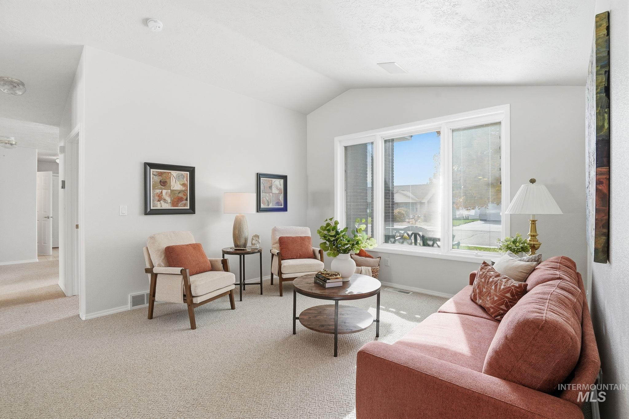 Living room featuring light carpet and vaulted ceiling