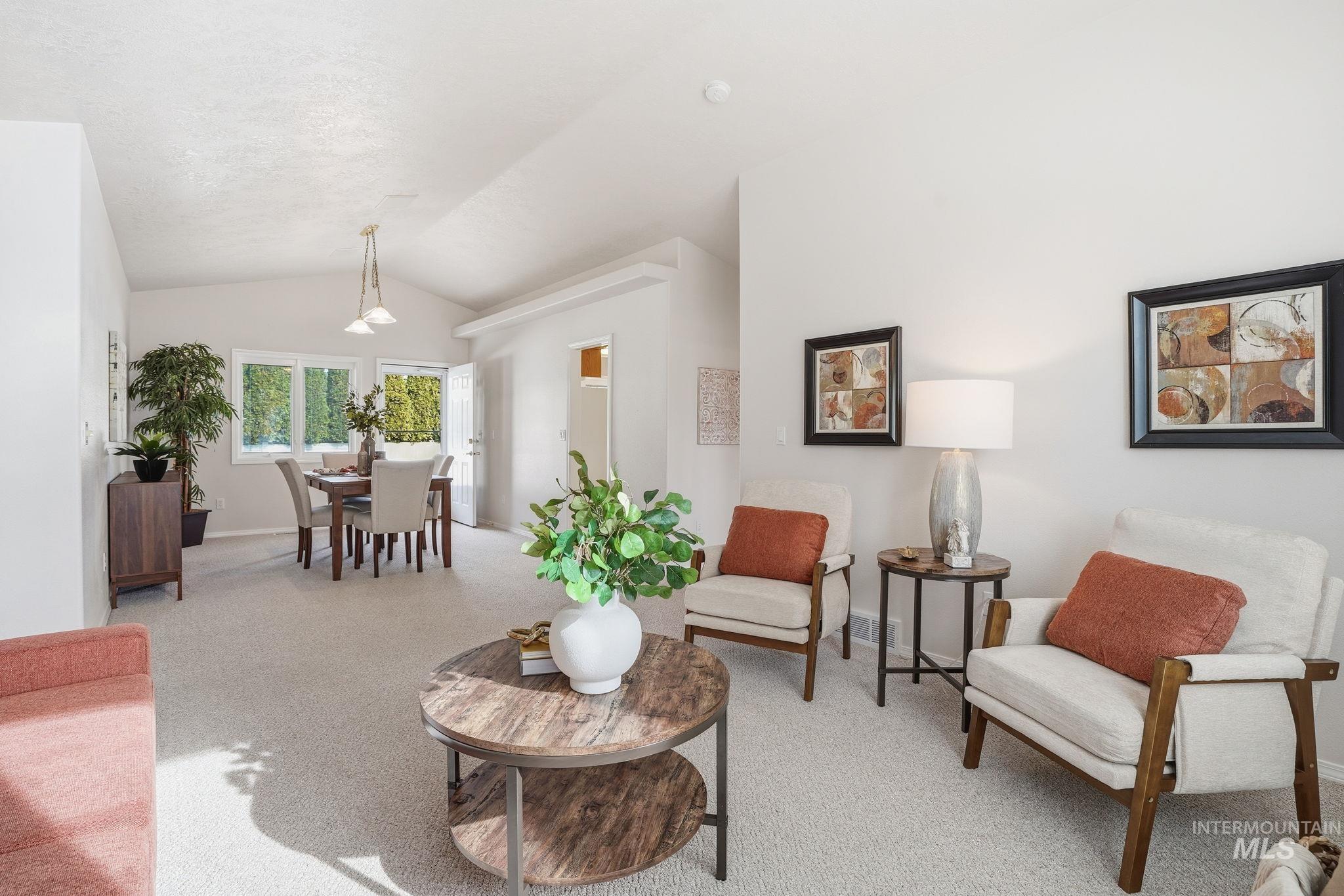 Living area featuring light carpet and lofted ceiling